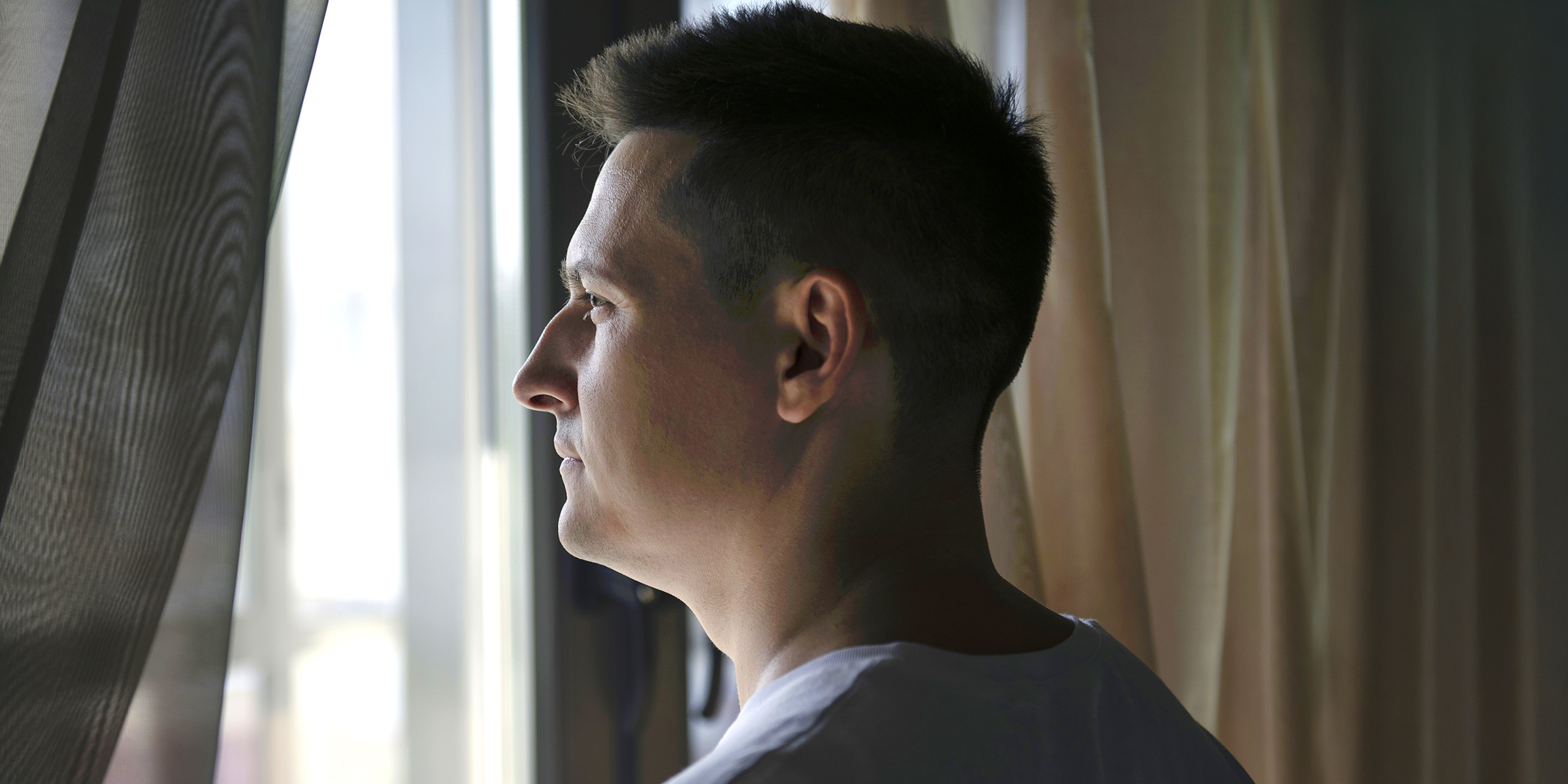 A man standing near a window | Source: Freepik