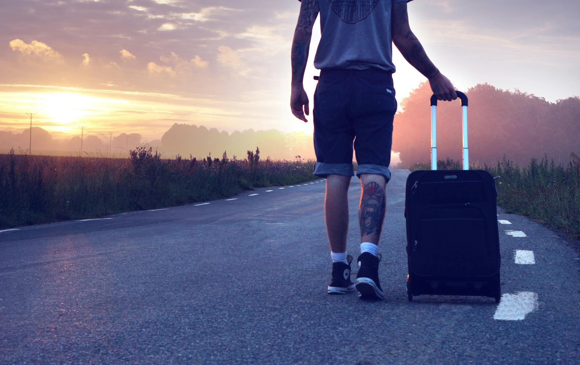 A man with luggage on the road | Source: Pexels