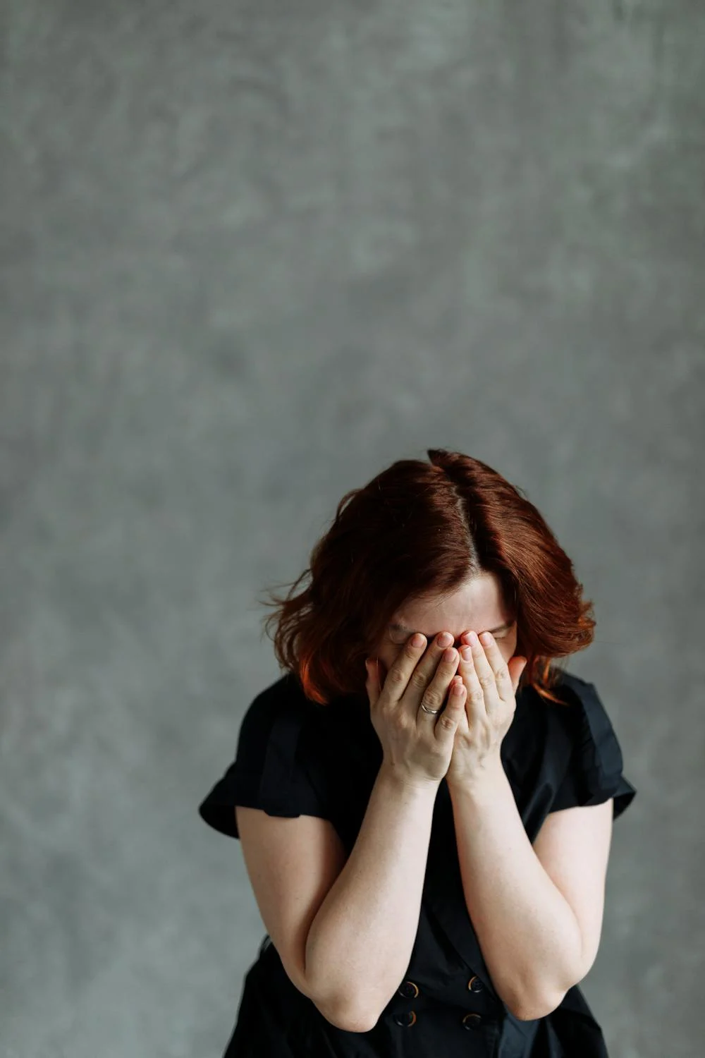 A crying woman covering her face with her hands | Source: Pexels