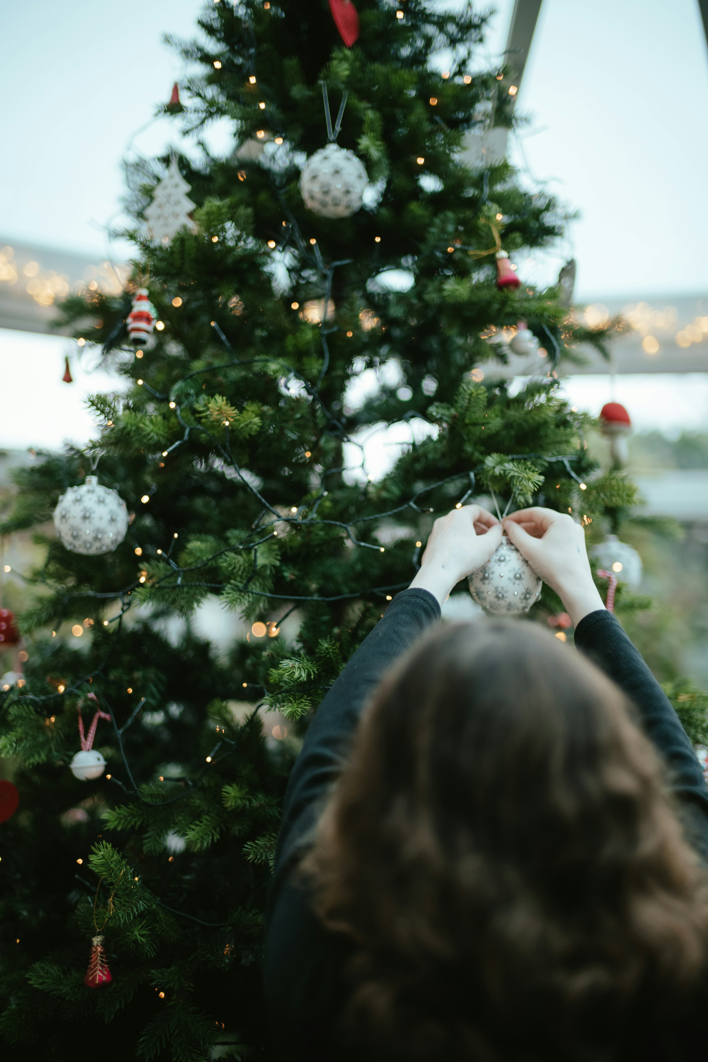 A woman decorating a Christmas tree | Source: Unsplash