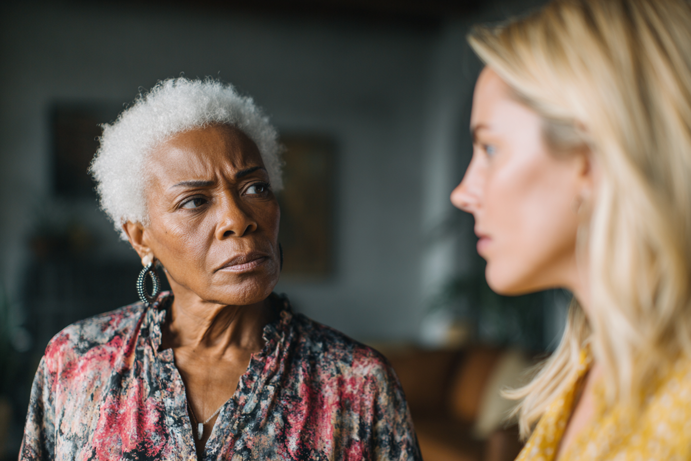 Two women glaring at each other in a living room | Source: Midjourney