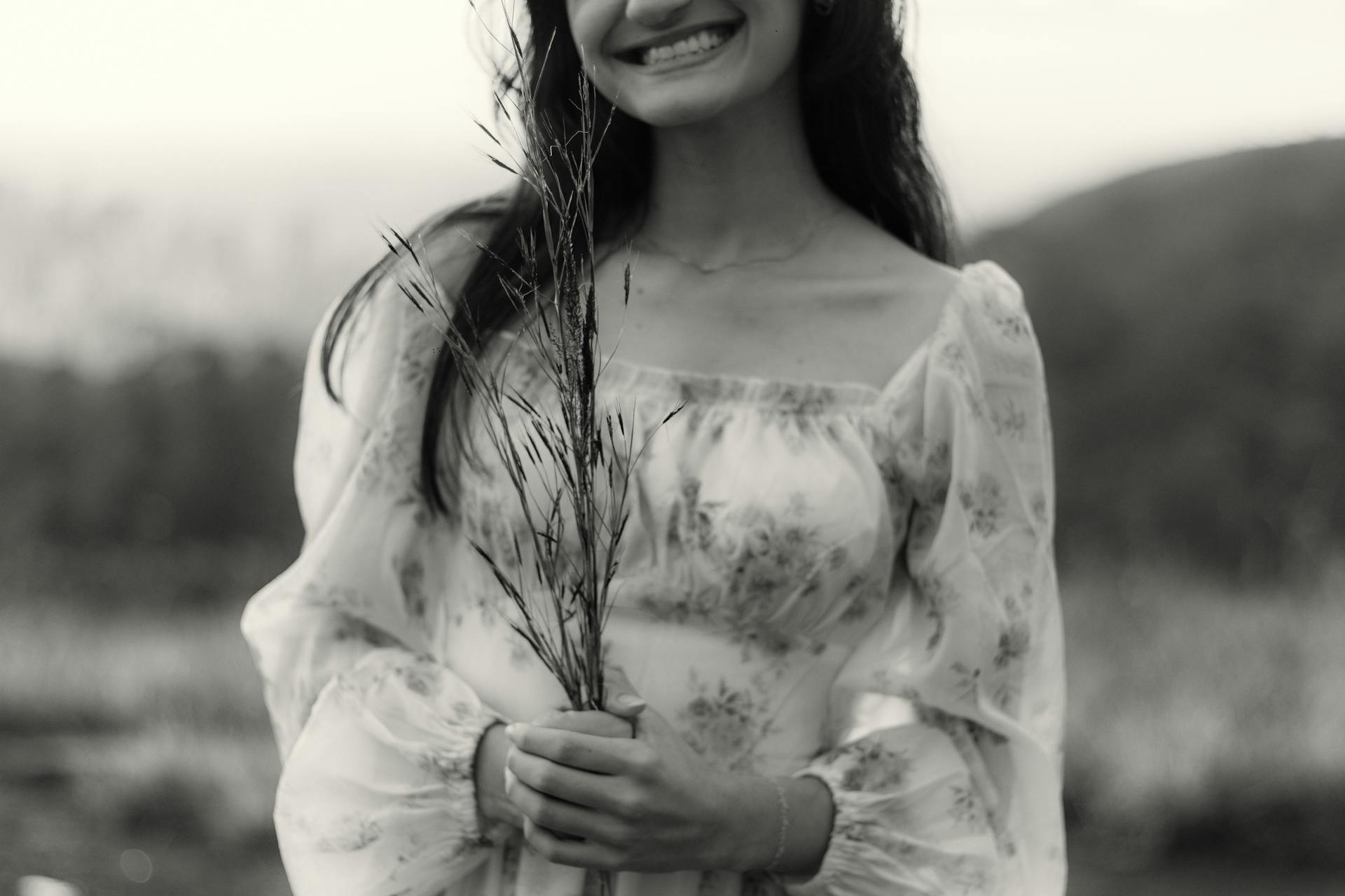 A grayscale photo of a smiling woman standing outdoors | Source: Pexels