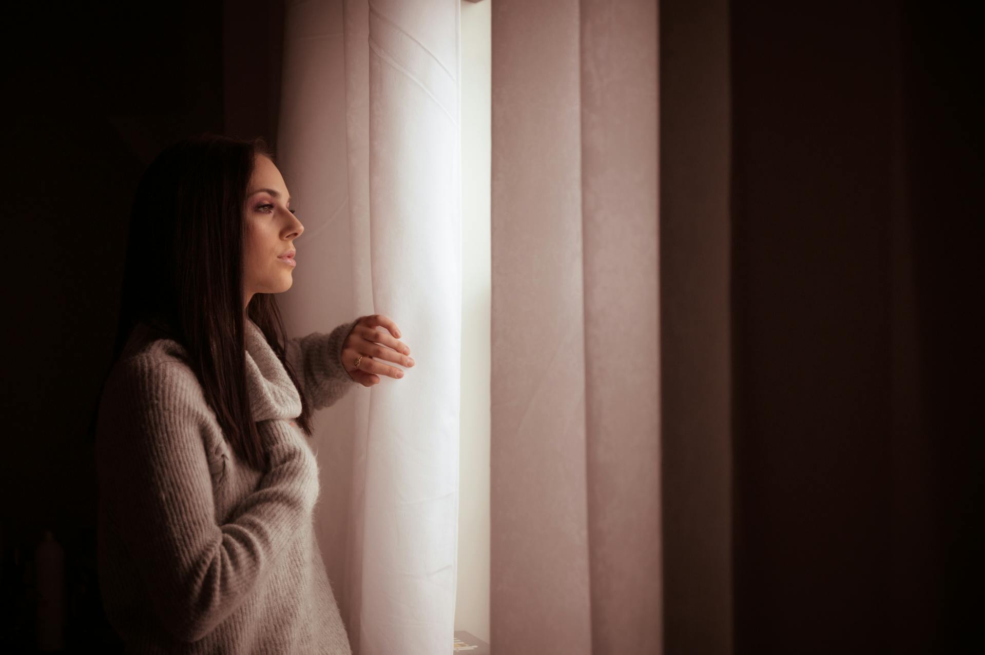 A thoughtful woman staring out a window | Source: Pexels
