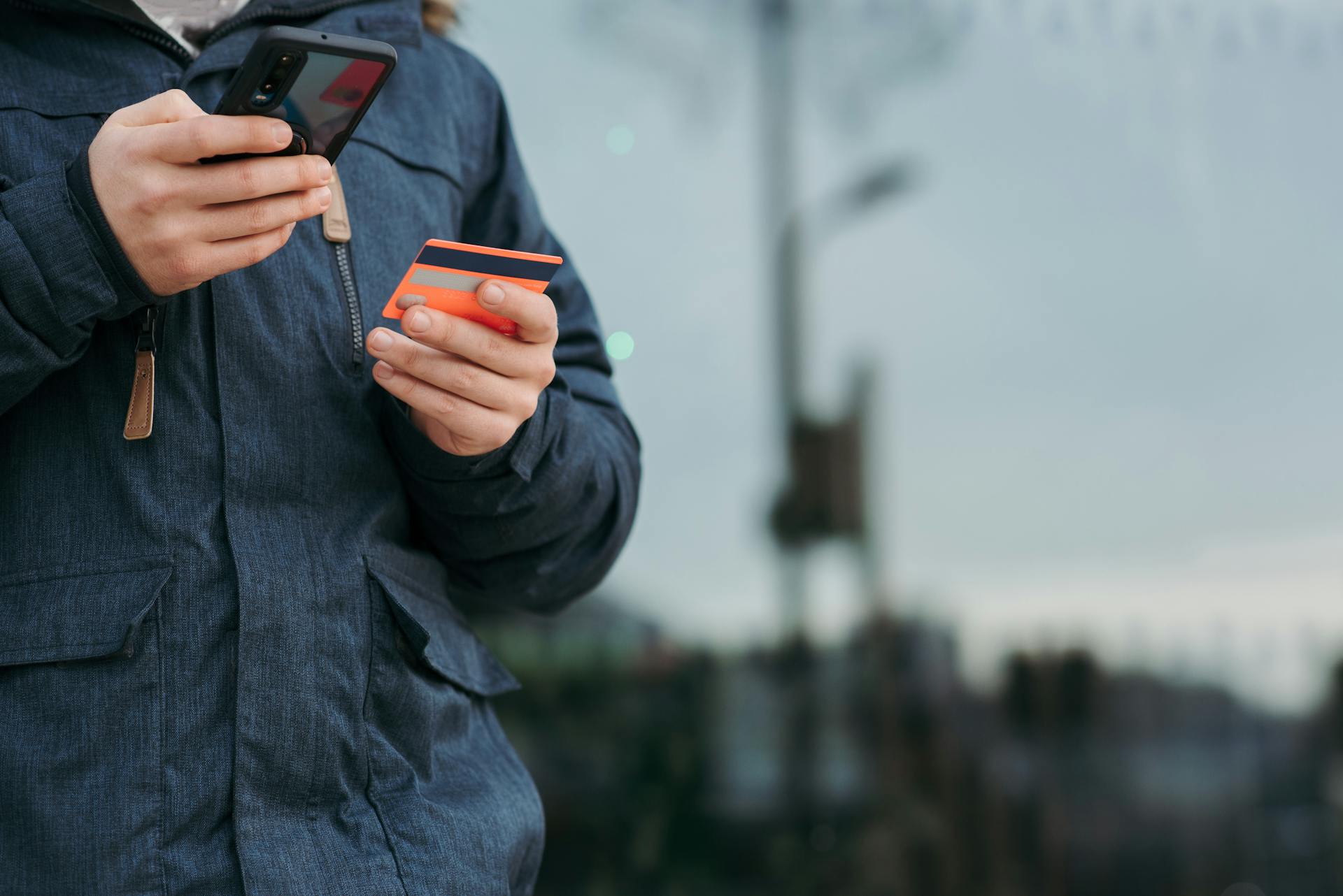 A man holding his card and phone | Source: Pexels