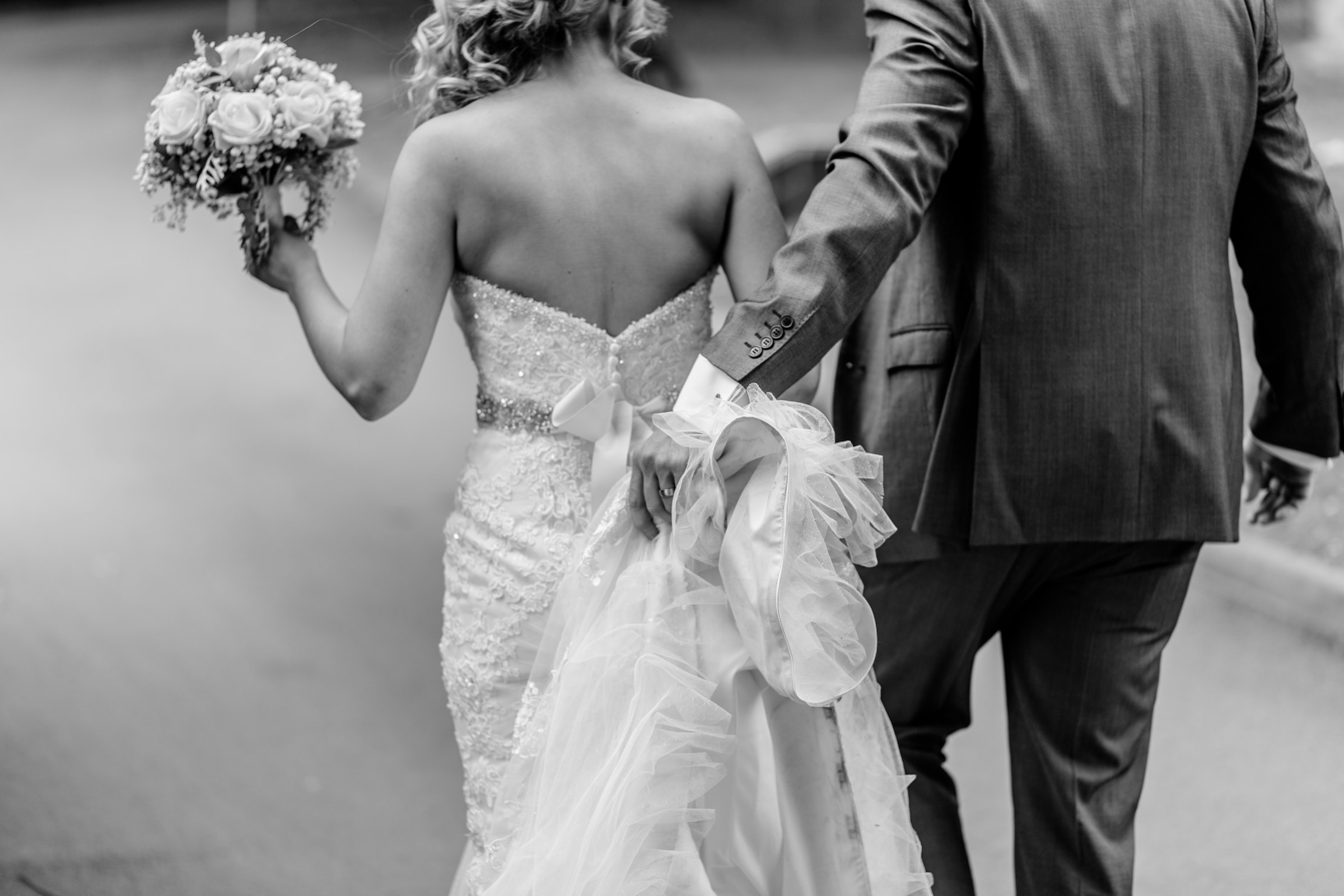 Grayscale of a bride and groom walking together | Source: Unsplash