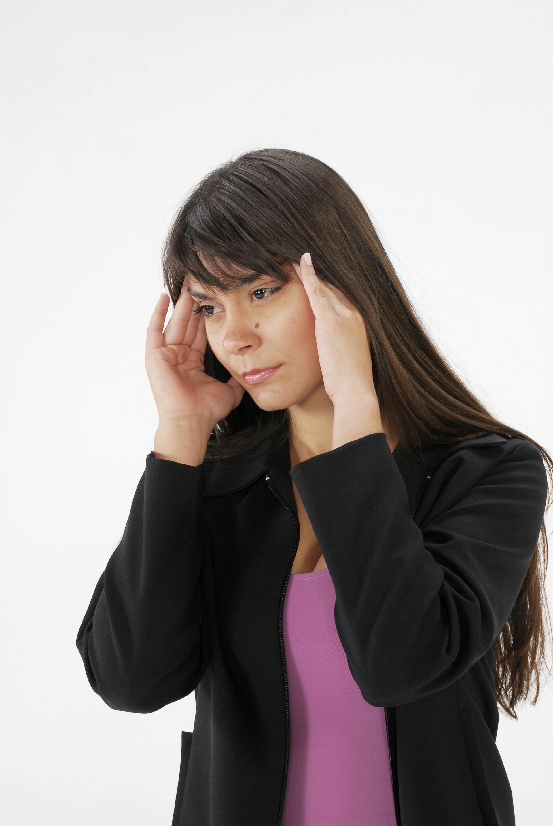 A woman rubbing at her temples | Source: Pexels