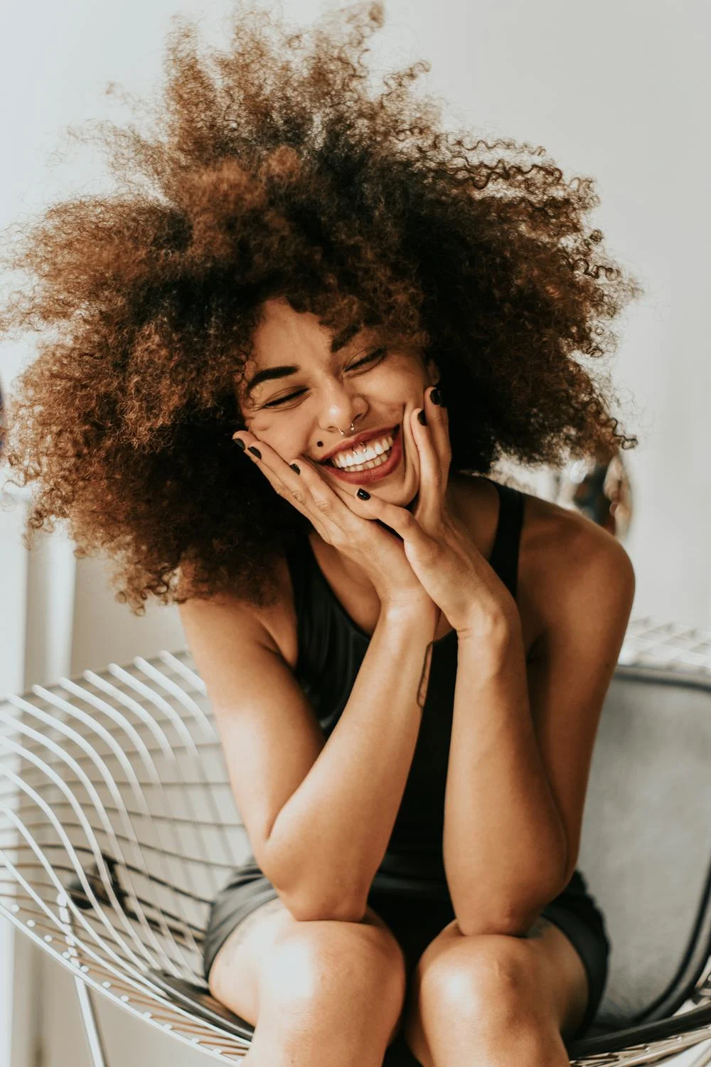 A smiling woman on a chair | Source: Pexels