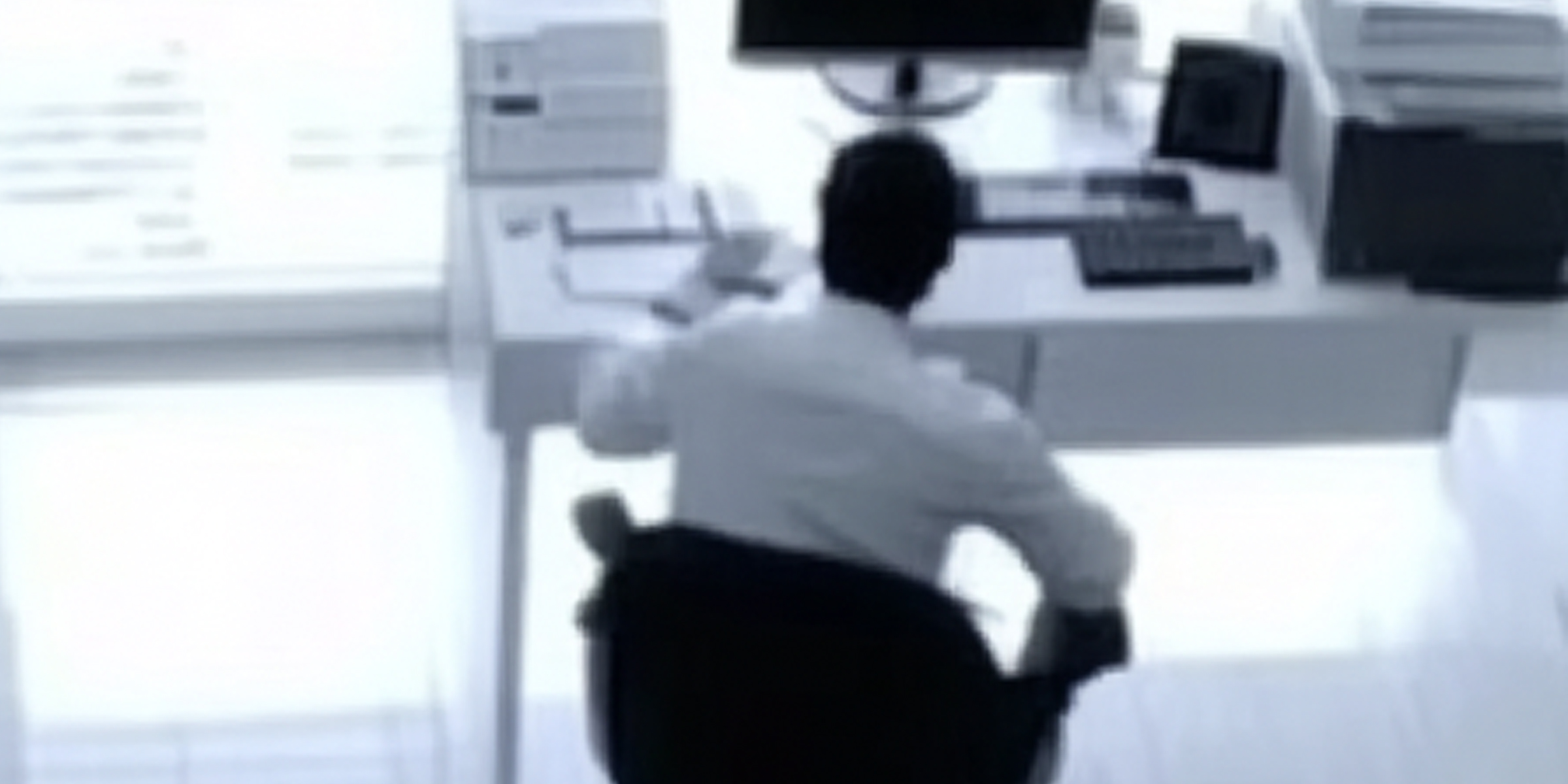 A blurry image of a man at his desk | Source: AmoMama