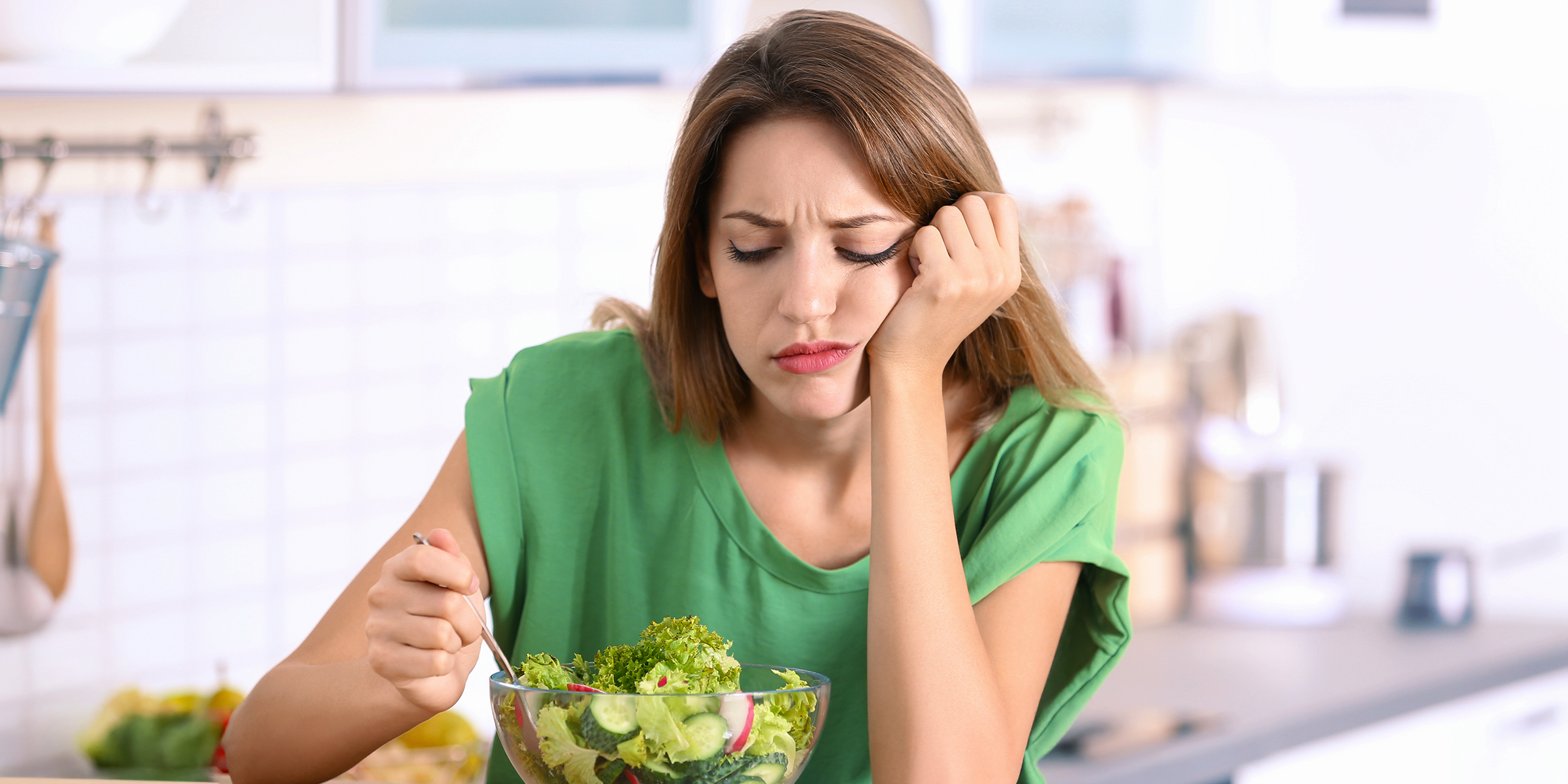 A bored woman looking at her salad | Source: Shutterstock