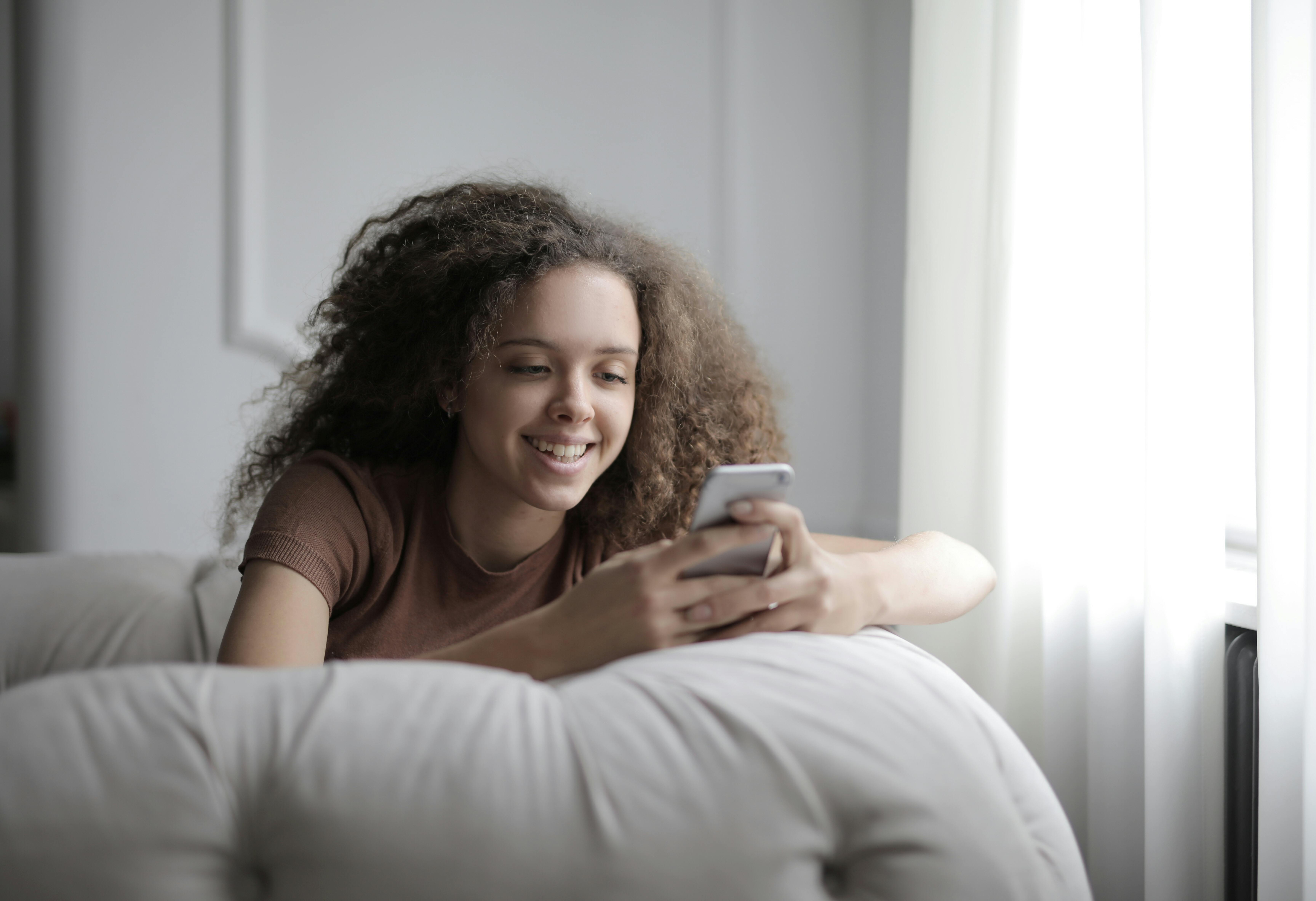 A happy girl on her phone | Source: Pexels
