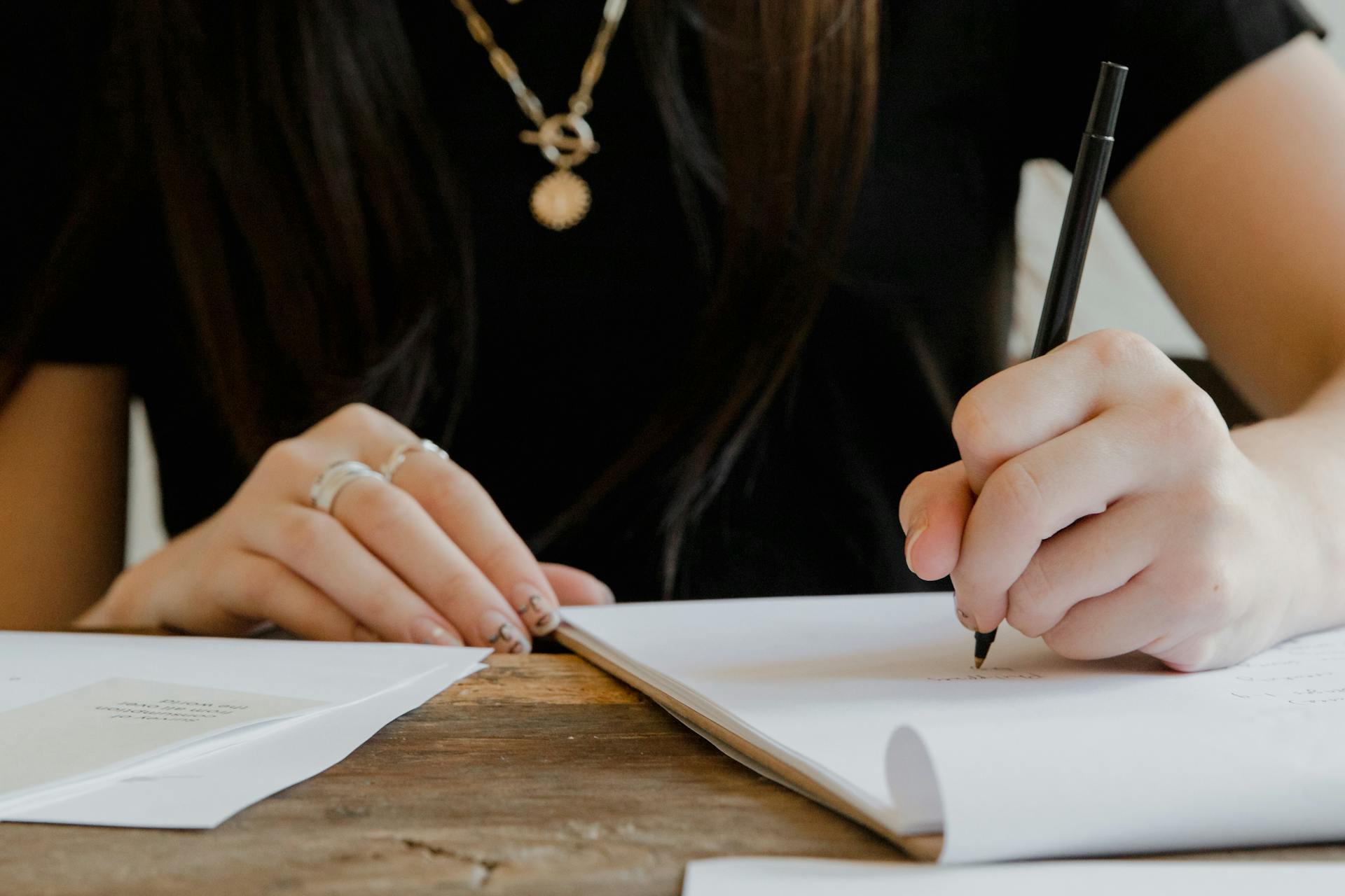 A woman writing on a paper | Source: Pexels