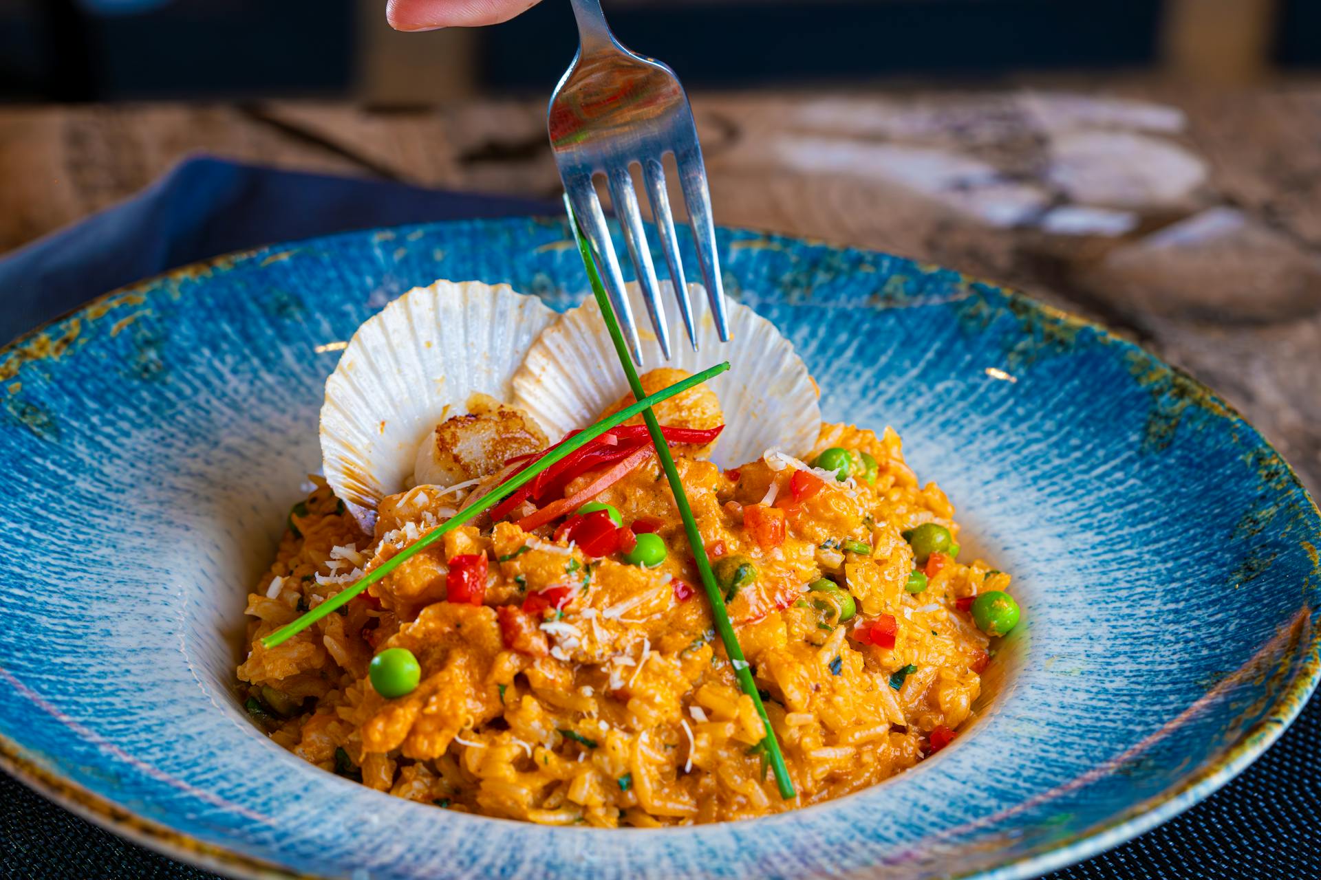 A fork poised over a plate of paella | Source: Pexels