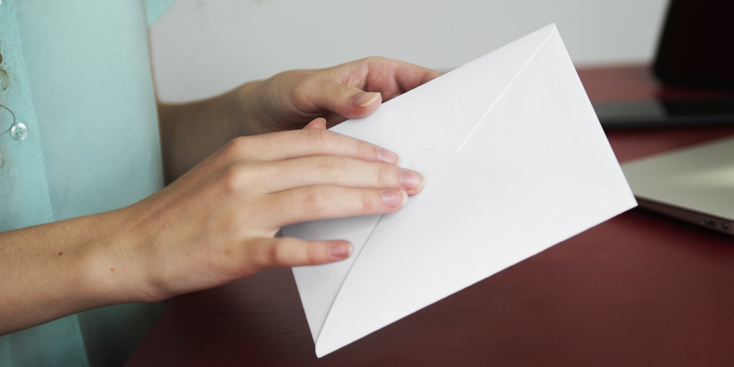 A woman holding a white envelope | Source: FreePik