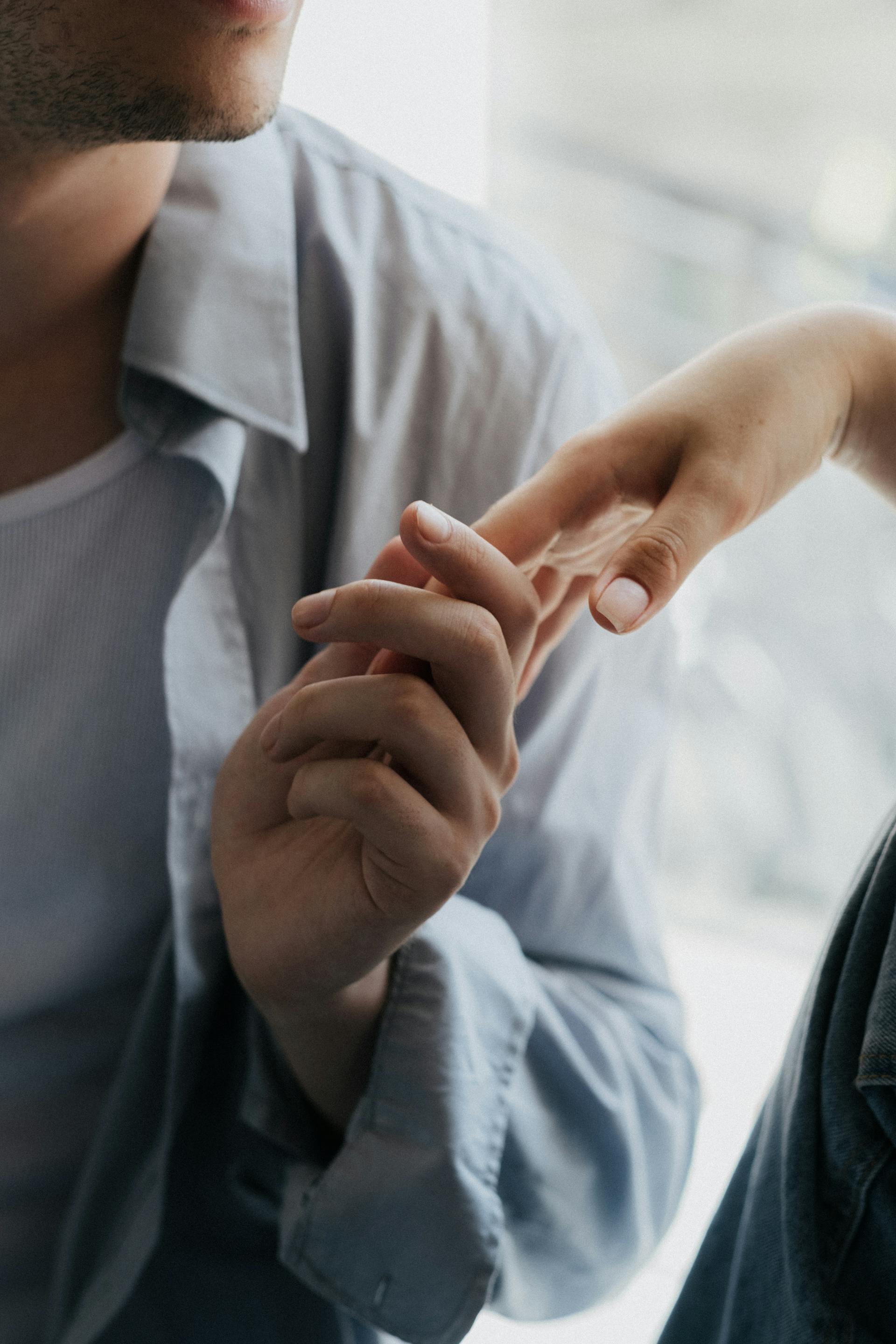 A man gently holding a woman's hand | Source: Pexels