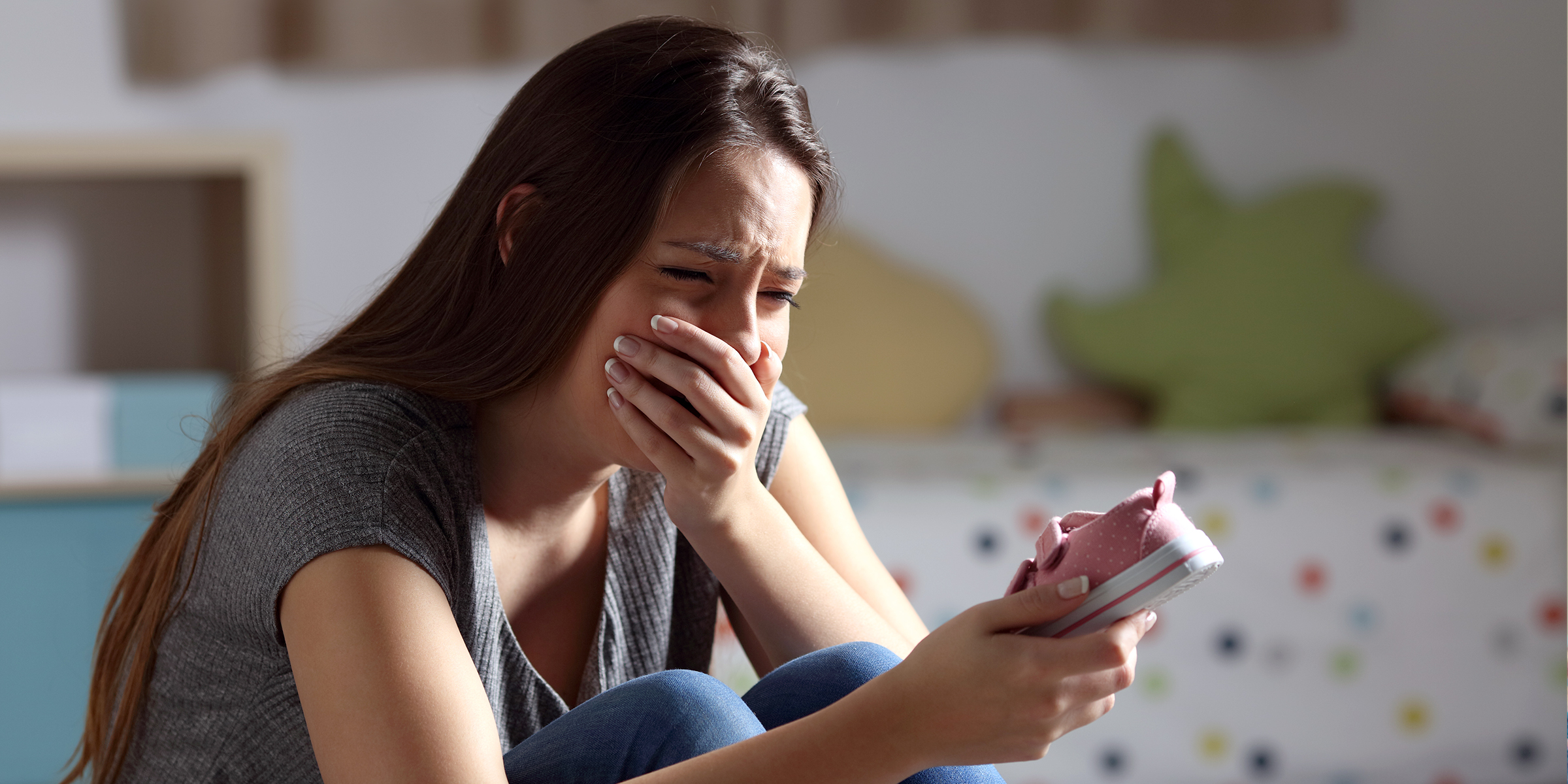 Woman crying with a little shoe in her hand | Source: Shutterstock