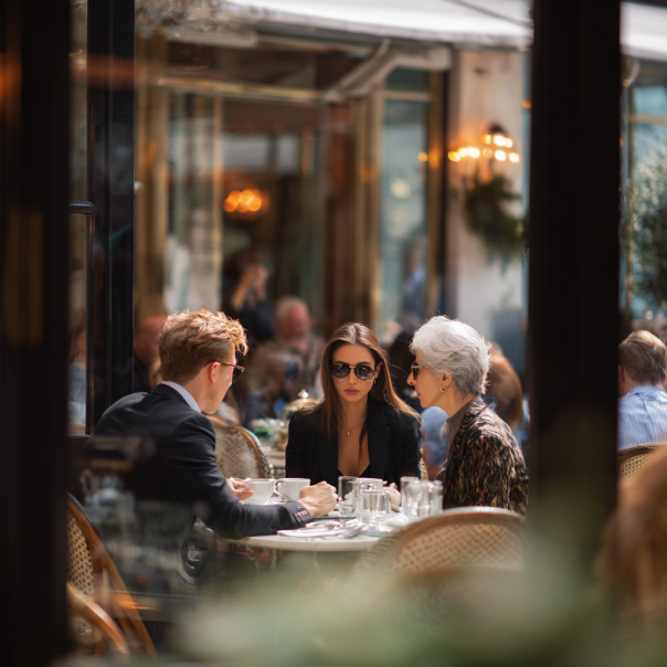 A son, his fiancée, and mother having coffee | Source: Midjourney