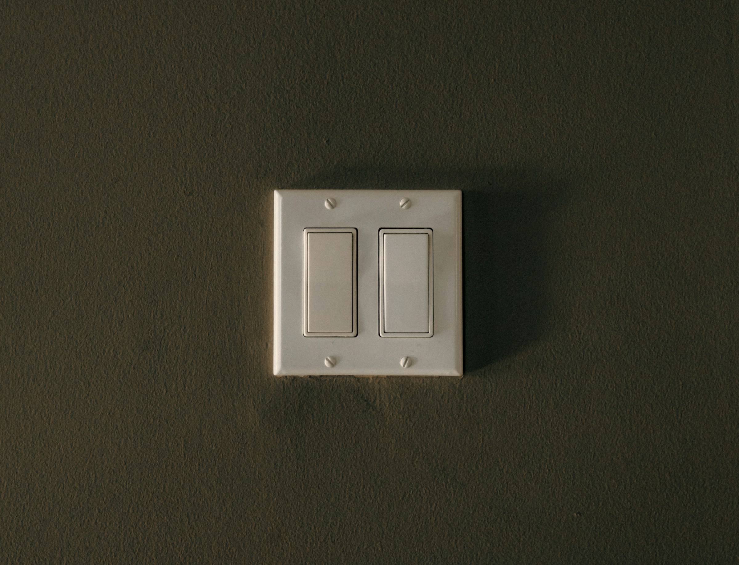 Double light switch buttons on a wall | Source: Unsplash