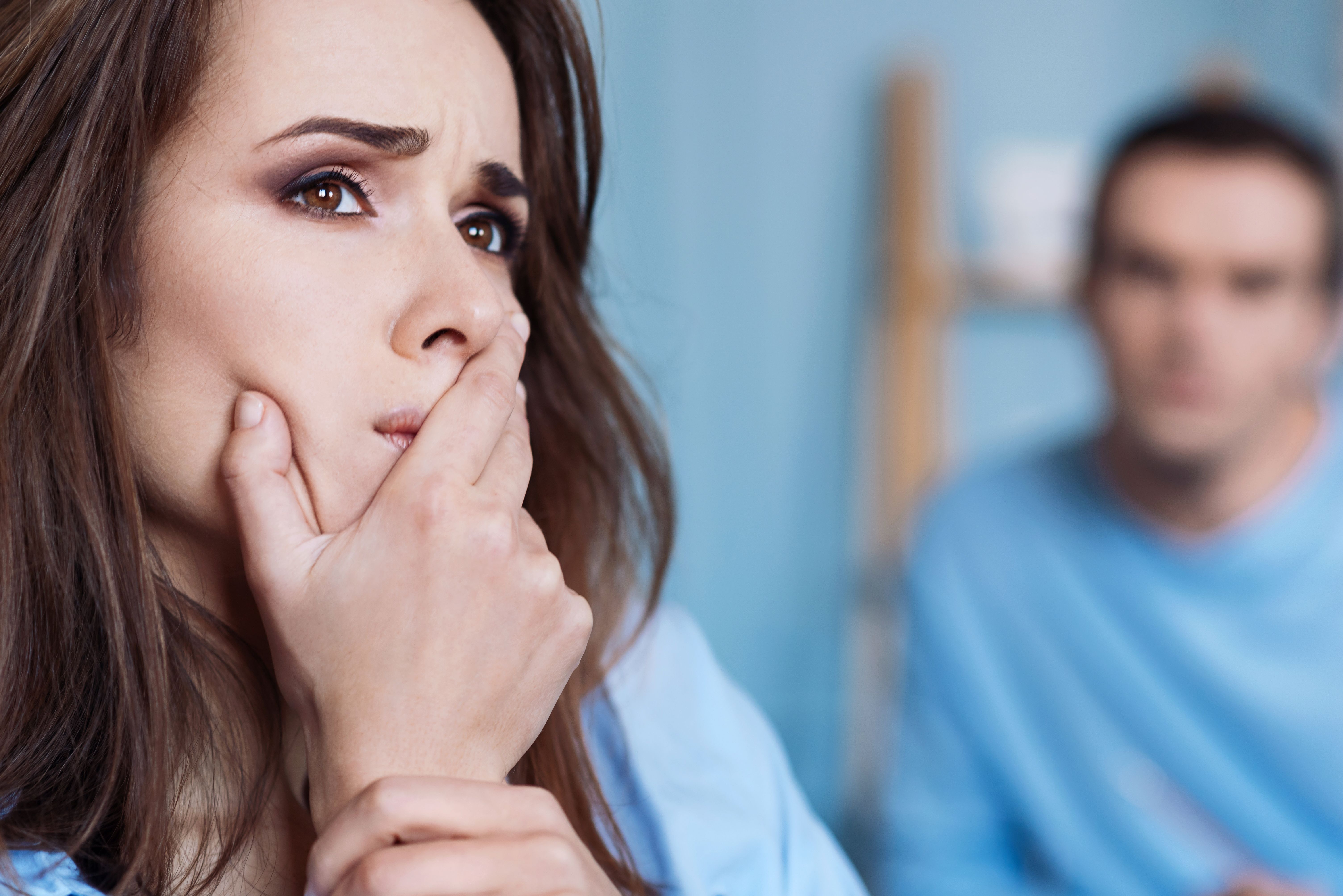 A worried-looking woman and a man behind her. | Source: Shutterstock