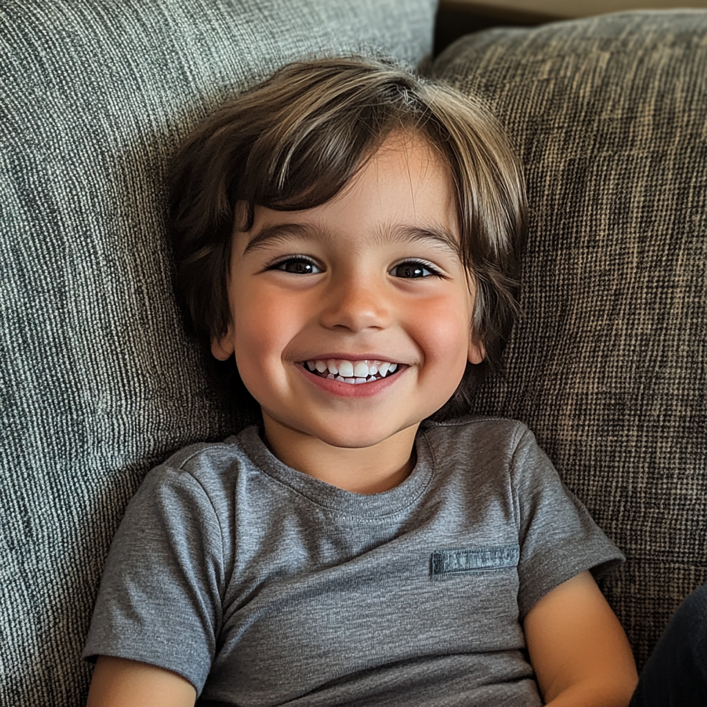 A little boy sitting on a couch | Source: Midjourney