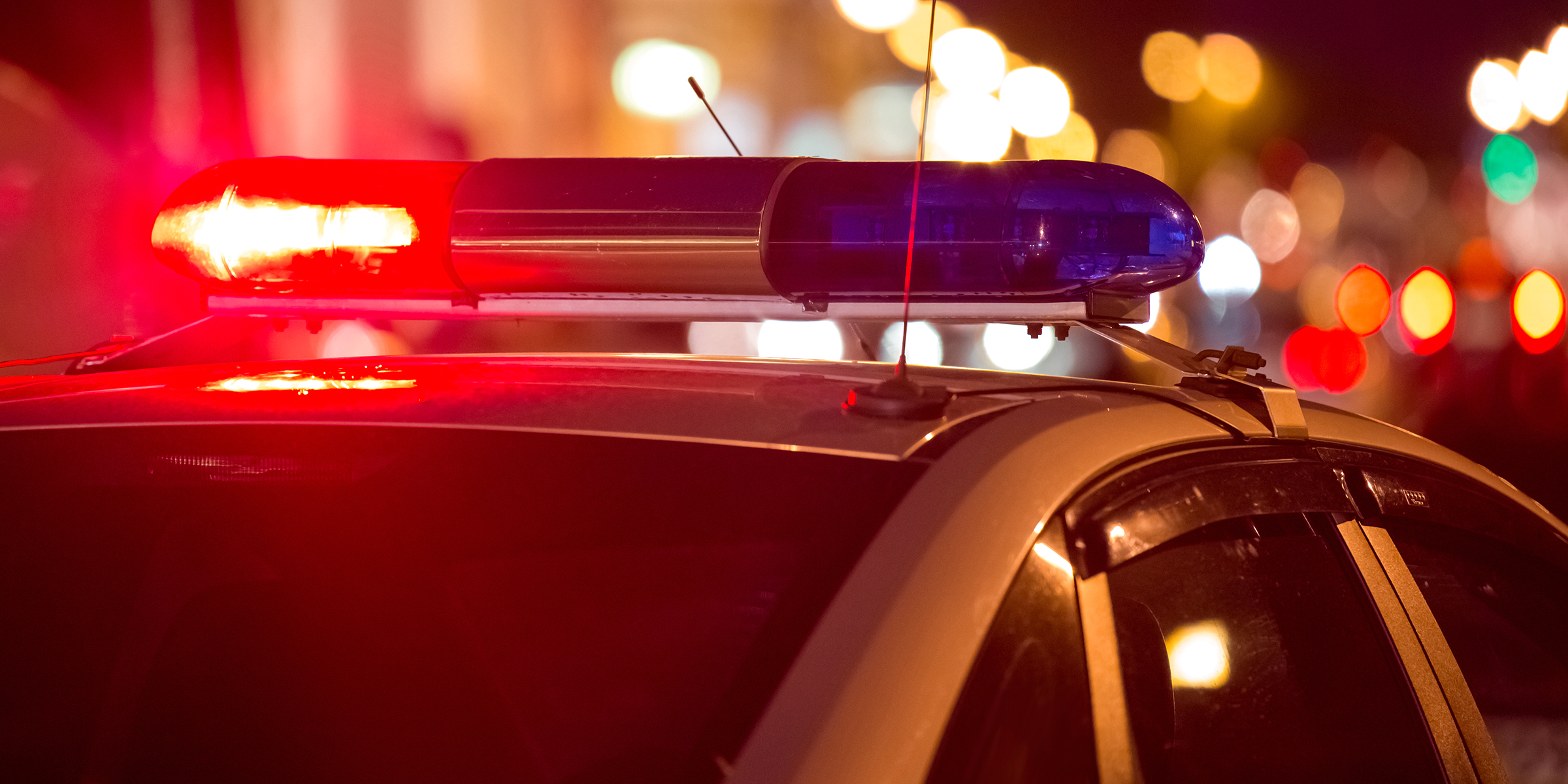 A police car with flashing red and blue lights at night | Source: Shutterstock