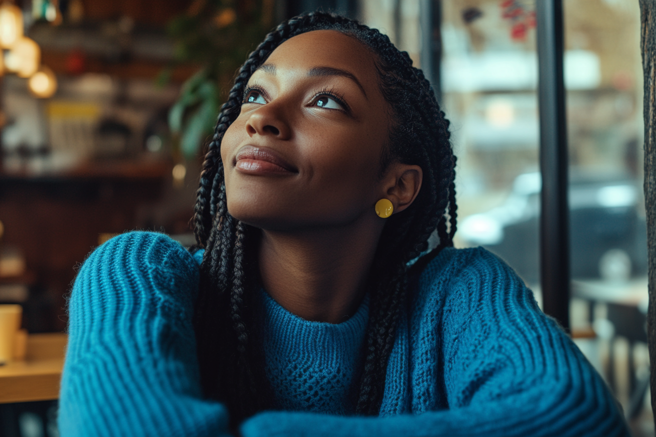 A woman looking up while seated at a table at a café | Source: Midjourney