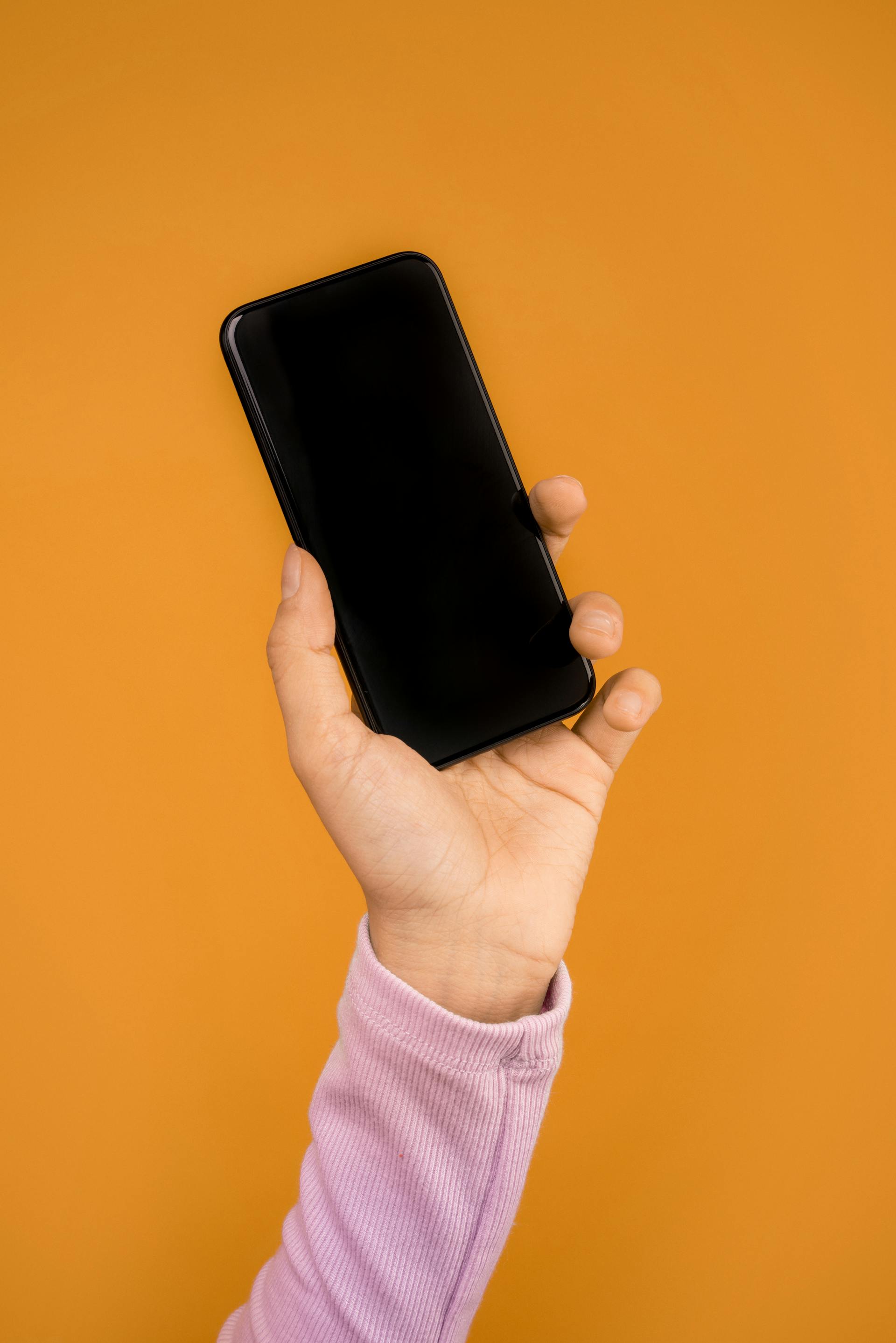 A woman holding a phone | Source: Pexels