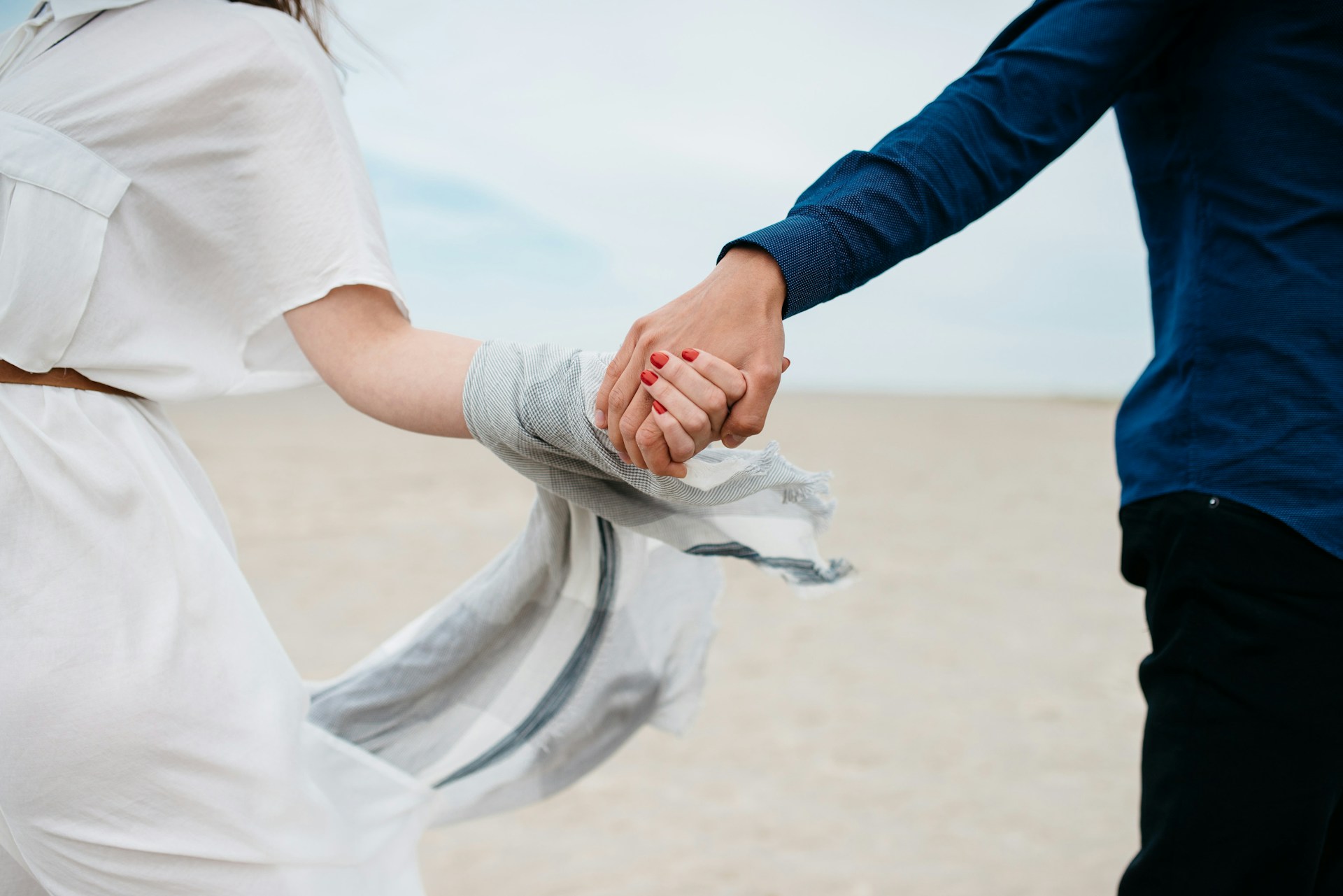 Cropped shot of young lovers holding hands | Source: Unsplash