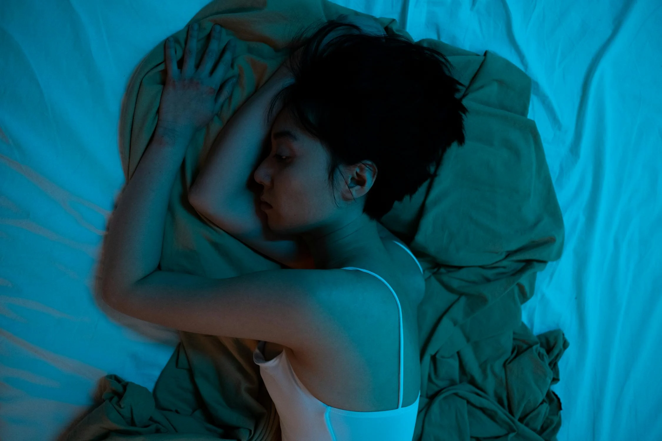 A woman in her bed with dim lights | Source: Pexels