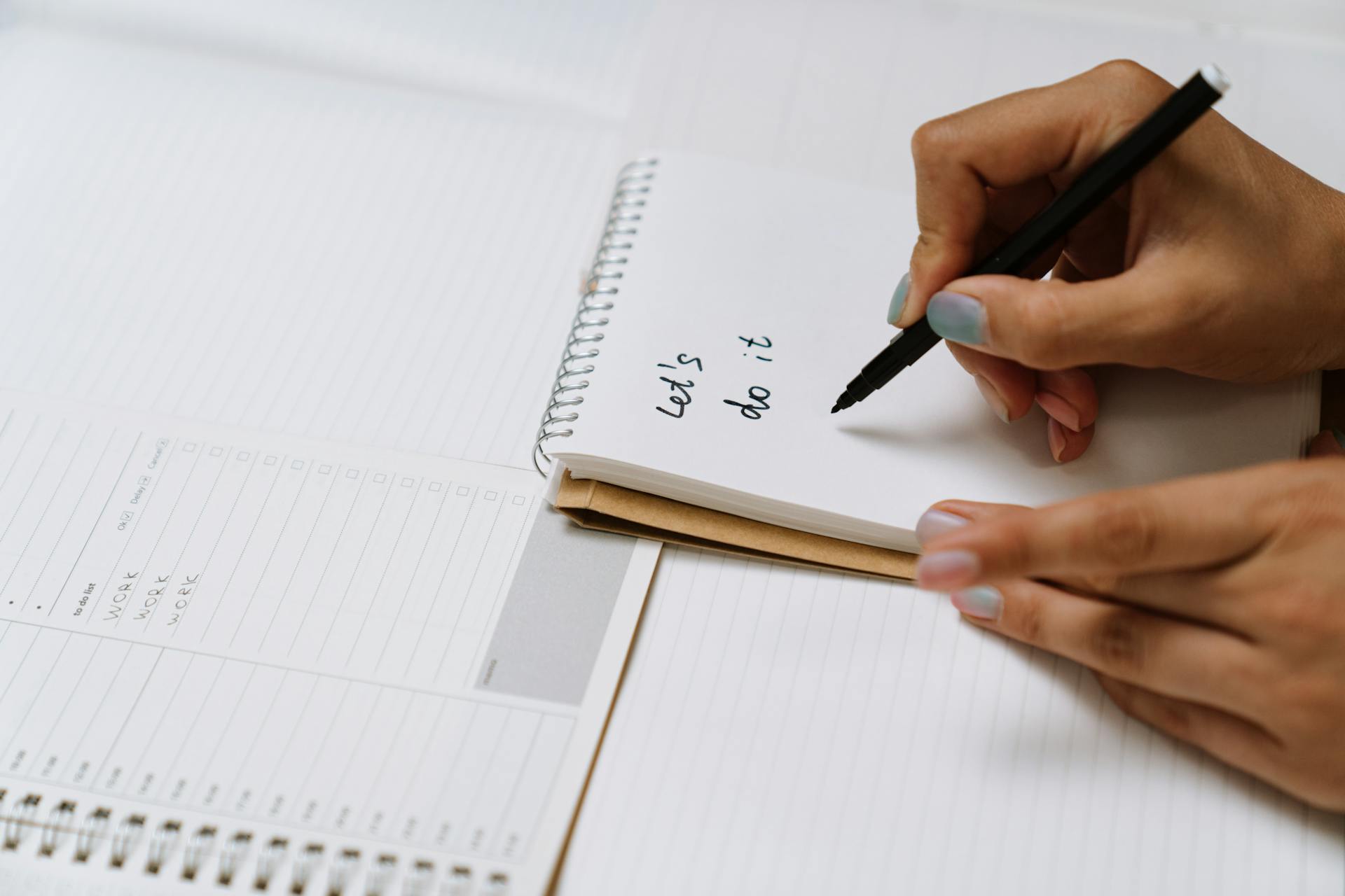 A woman writing on a notepad | Source: Pexels