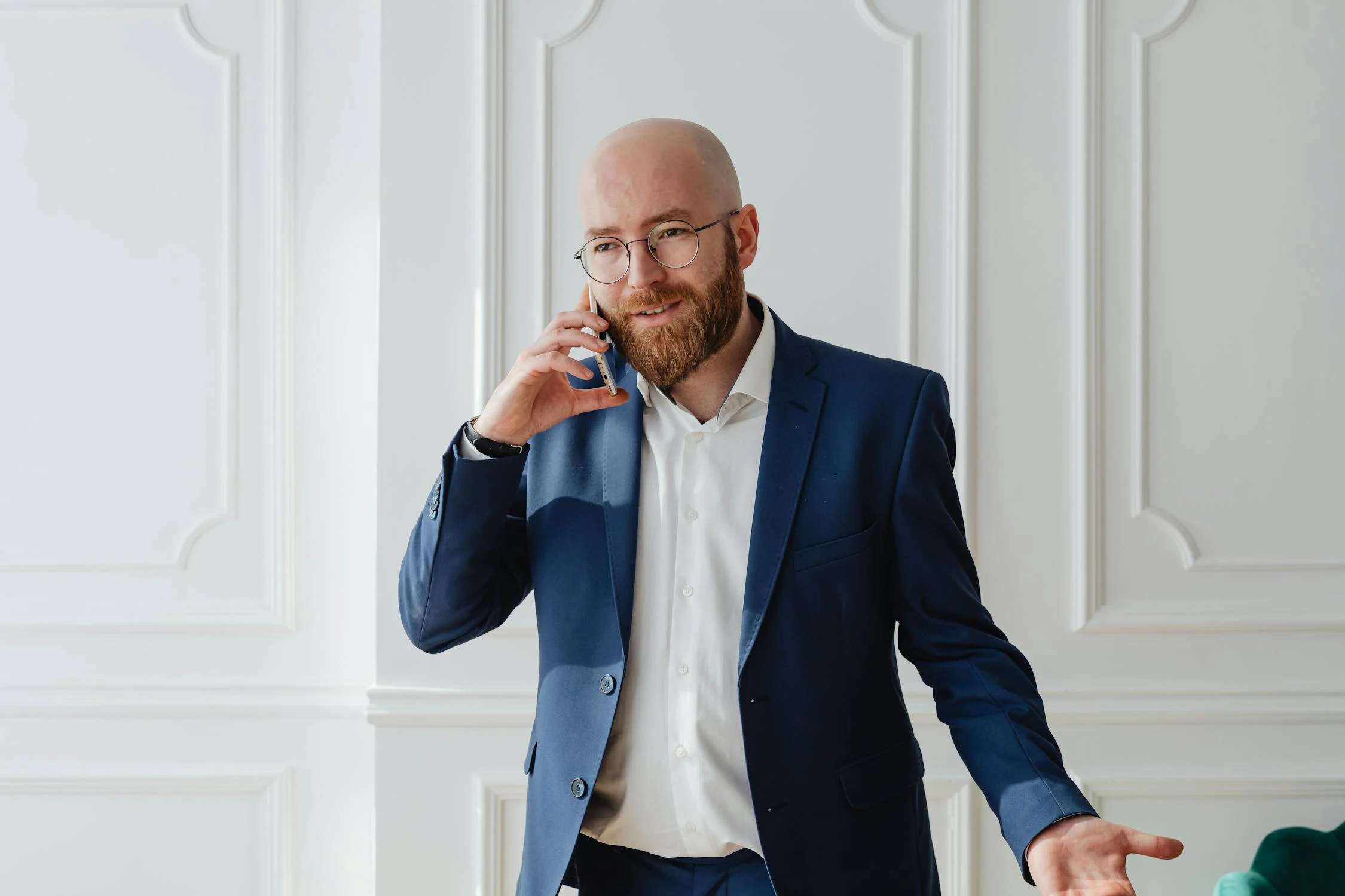 A smiling man in a suit talking on his phone | Source: Pexels