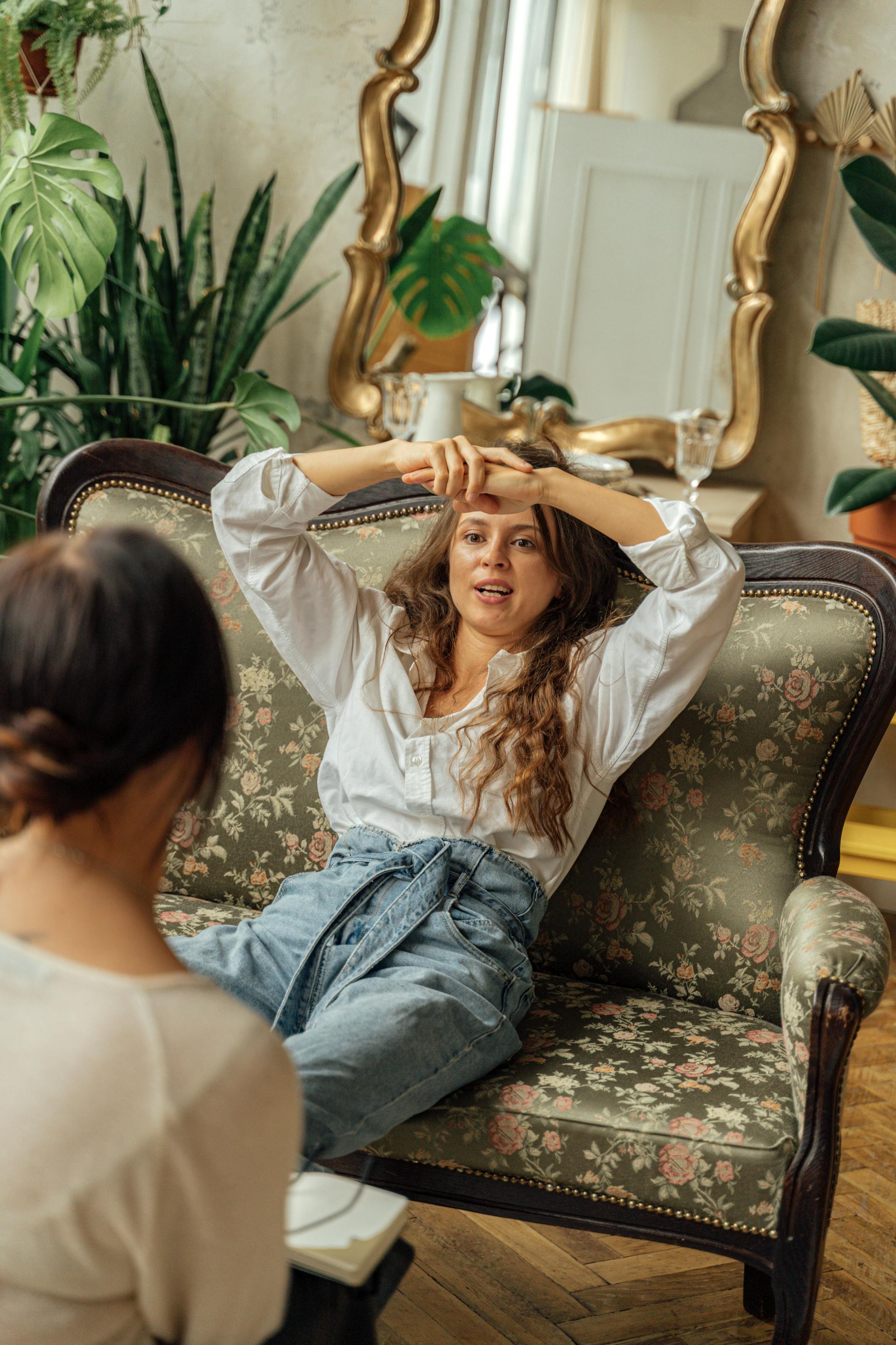 A woman talking to her friend while sitting on the sofa | Source: Pexels