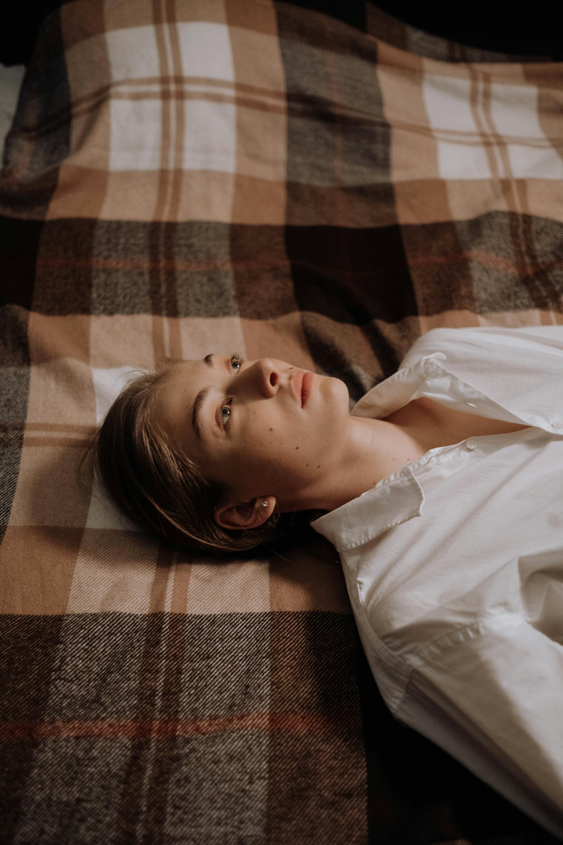 A woman lying awake in bed | Source: Pexels