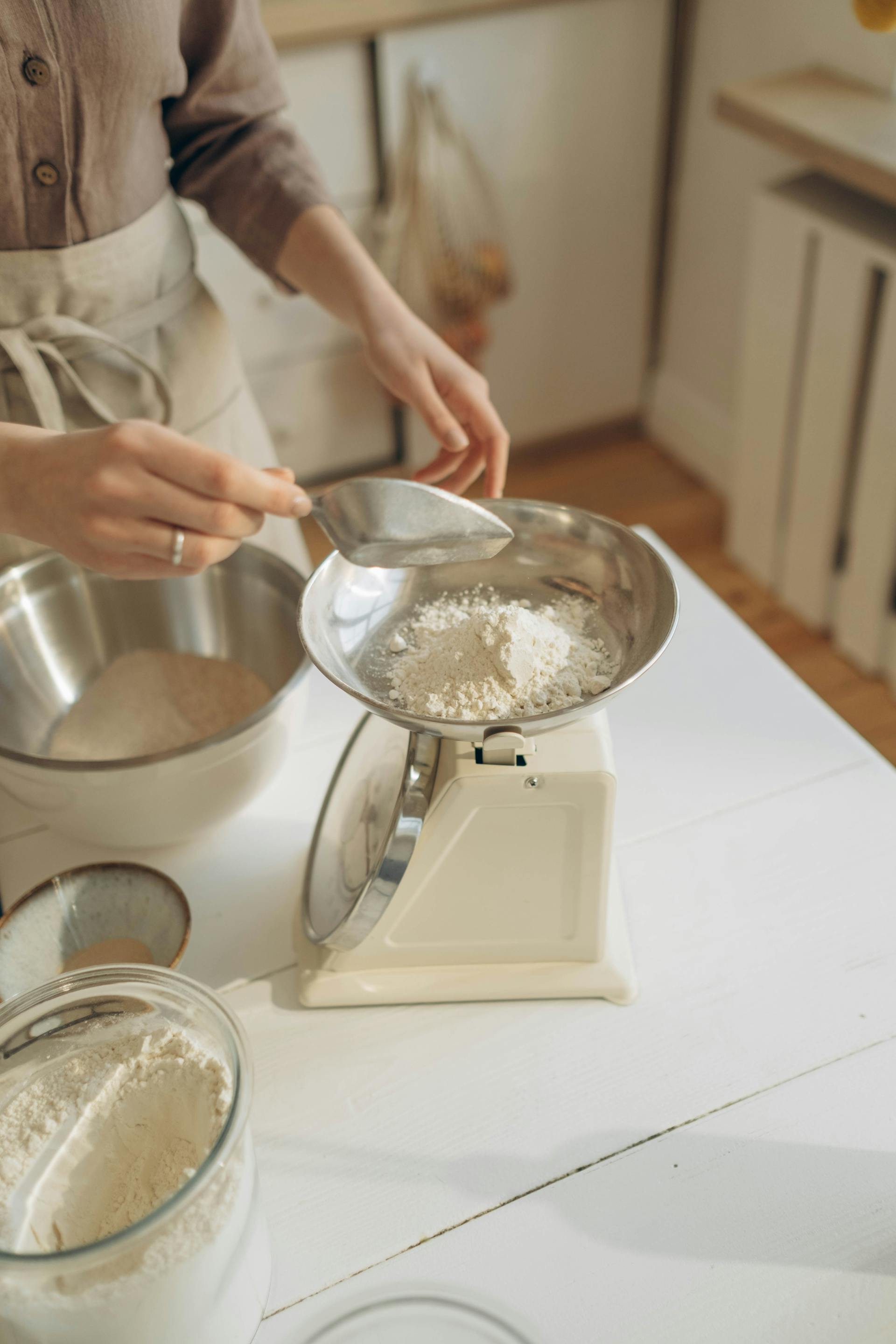 A woman putting flour on a weighing scale | Source: Pexels