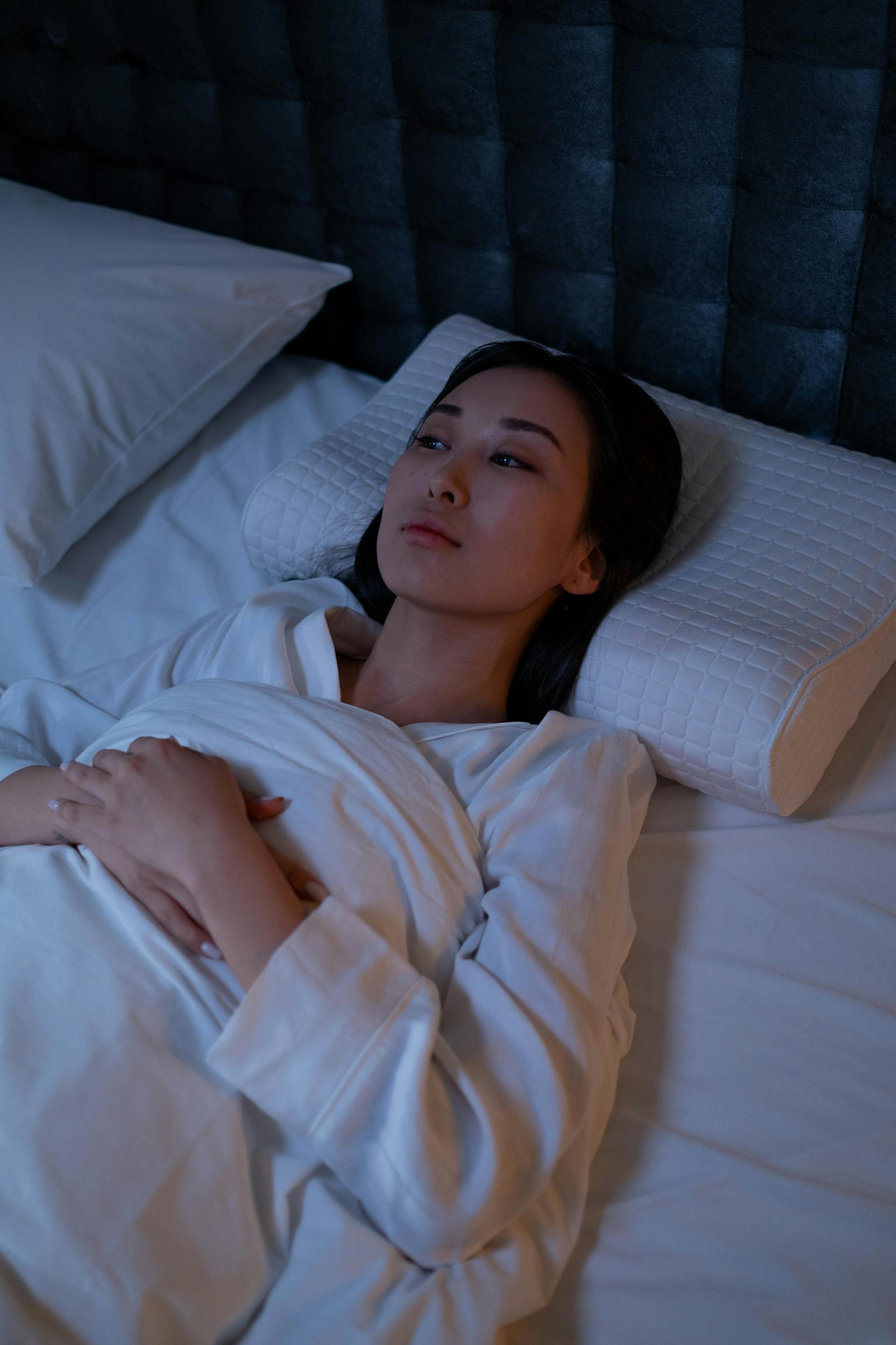 A woman lying awake in bed | Source: Pexels