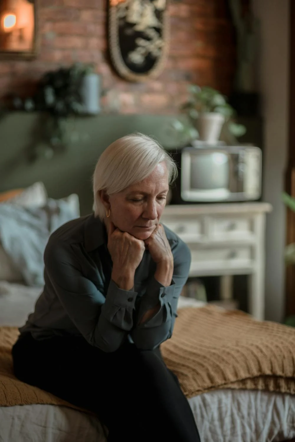 A sad woman sitting on her bed | Source: Pexels