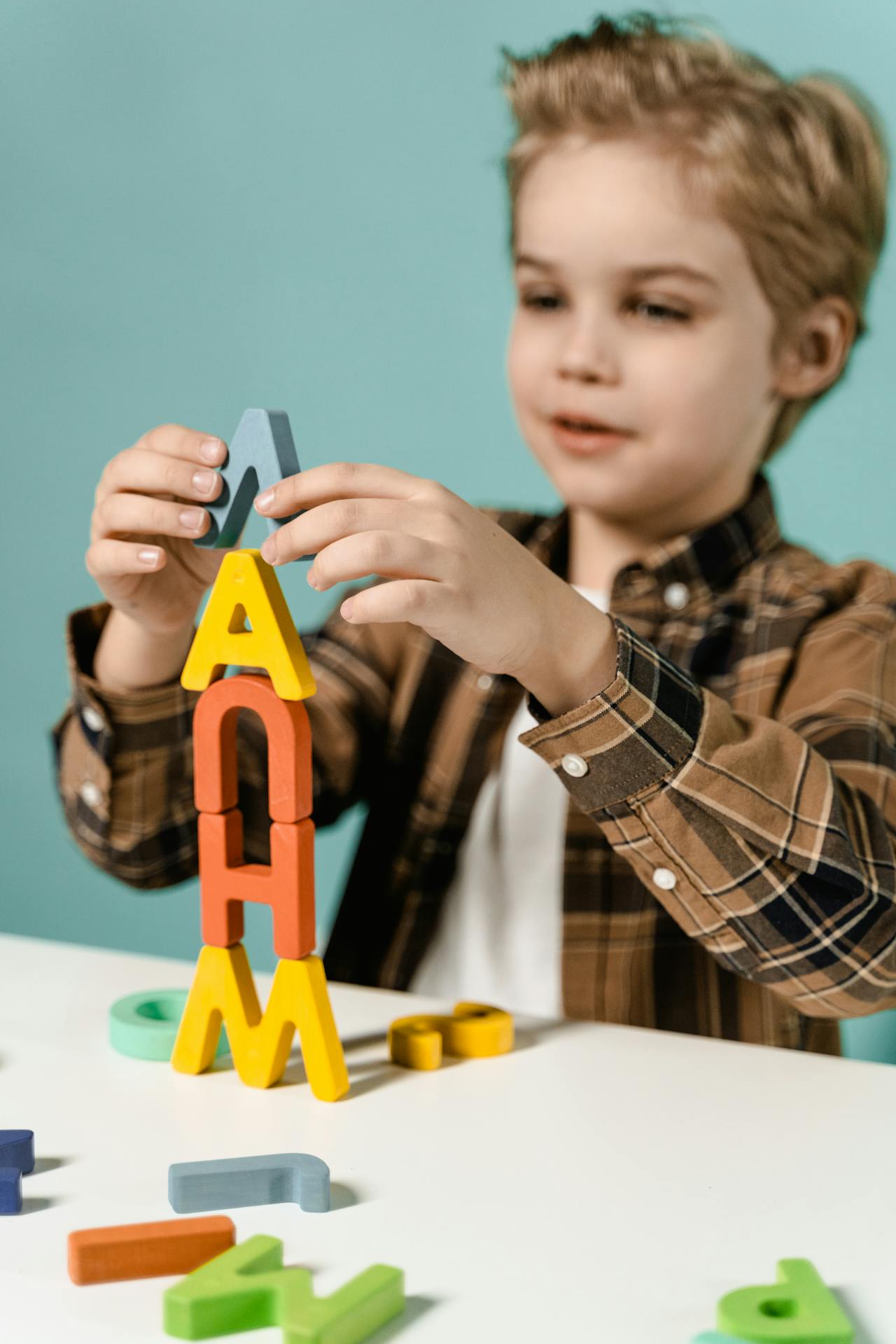 A little boy stacking letter blocks | Source: Pexels