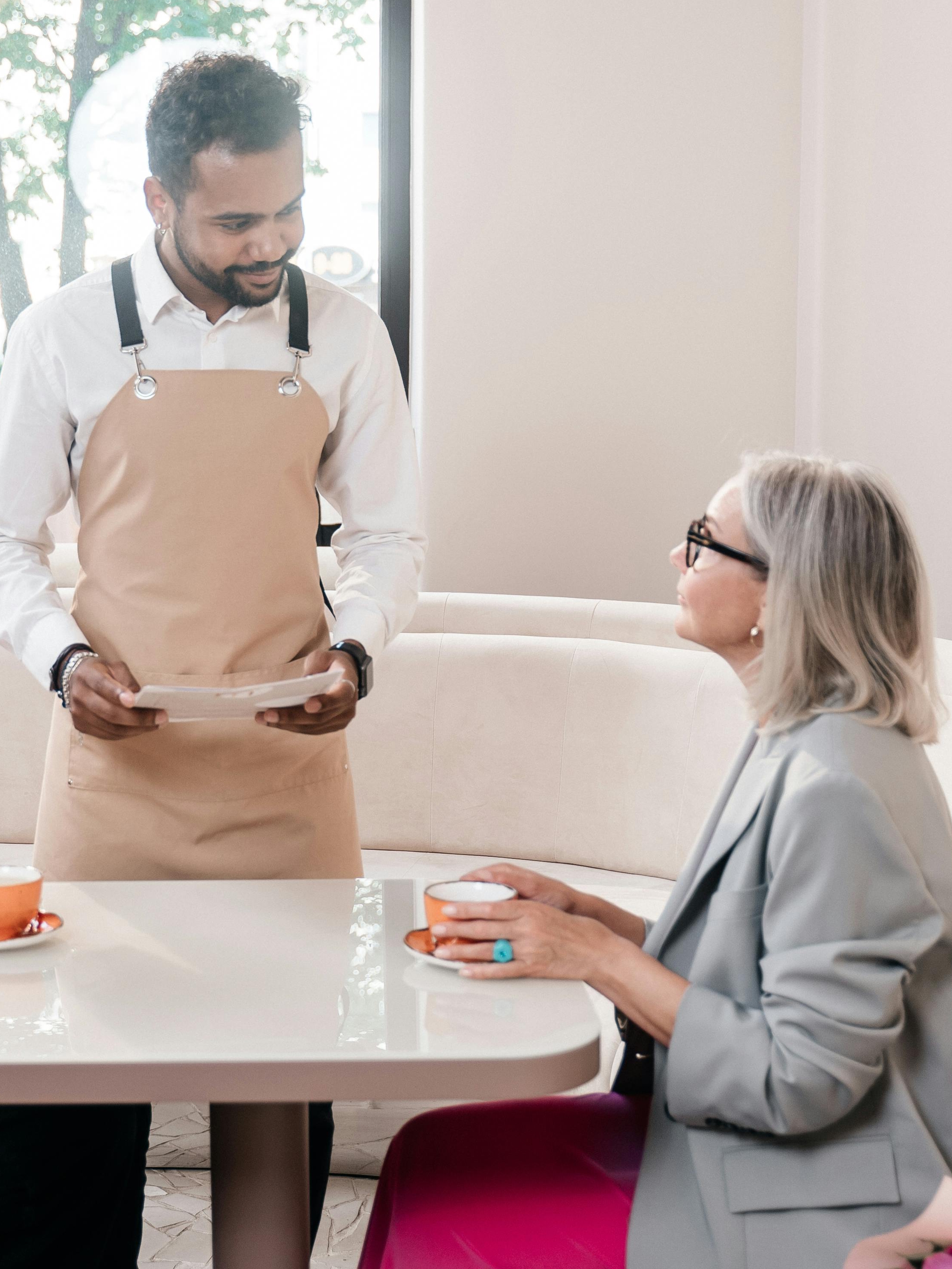 Um garçom discute algo com um cliente do restaurante | Fonte: Pexels