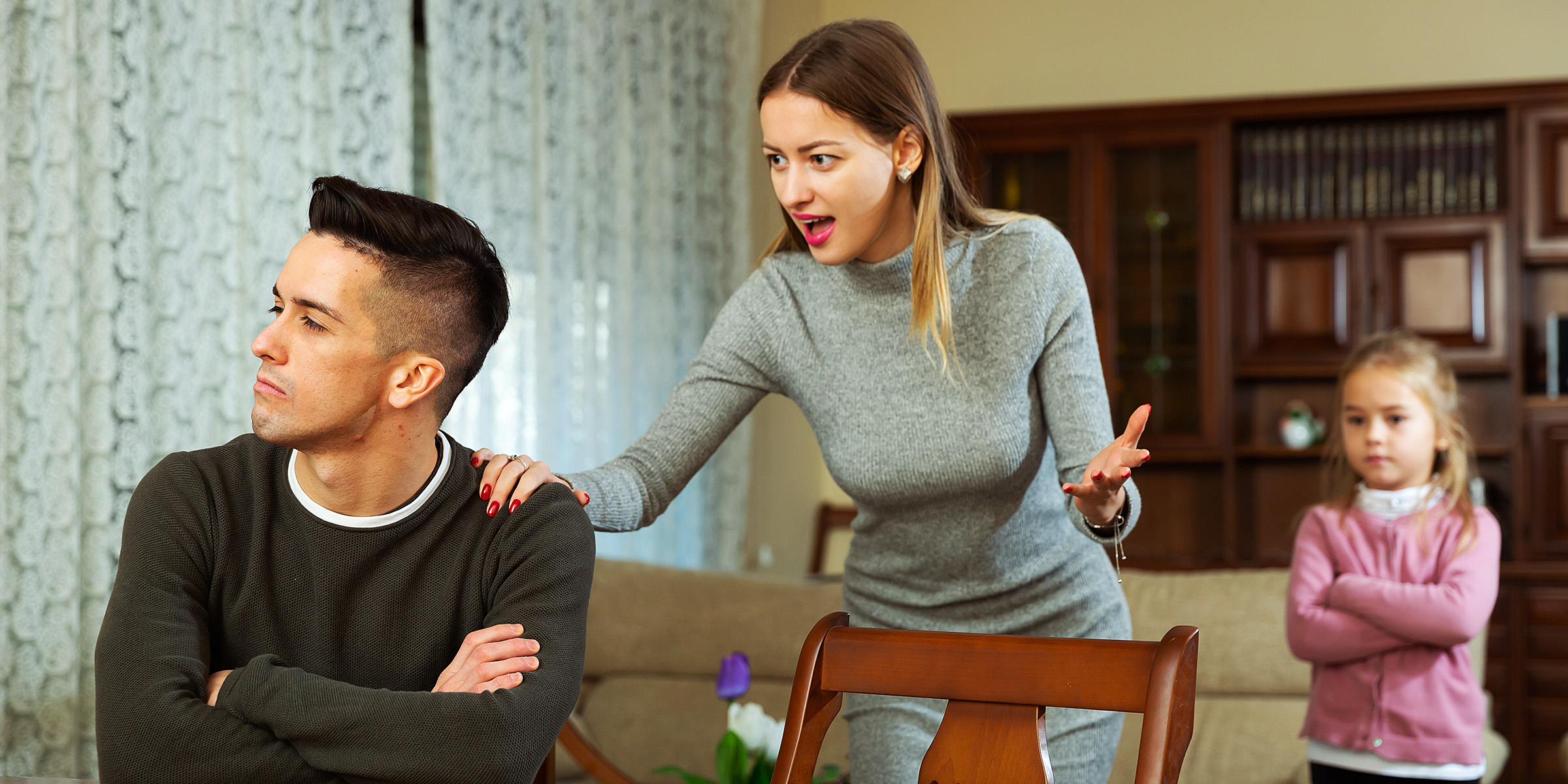 A tense moment between a couple while their daughter looks on | Source: Shutterstock