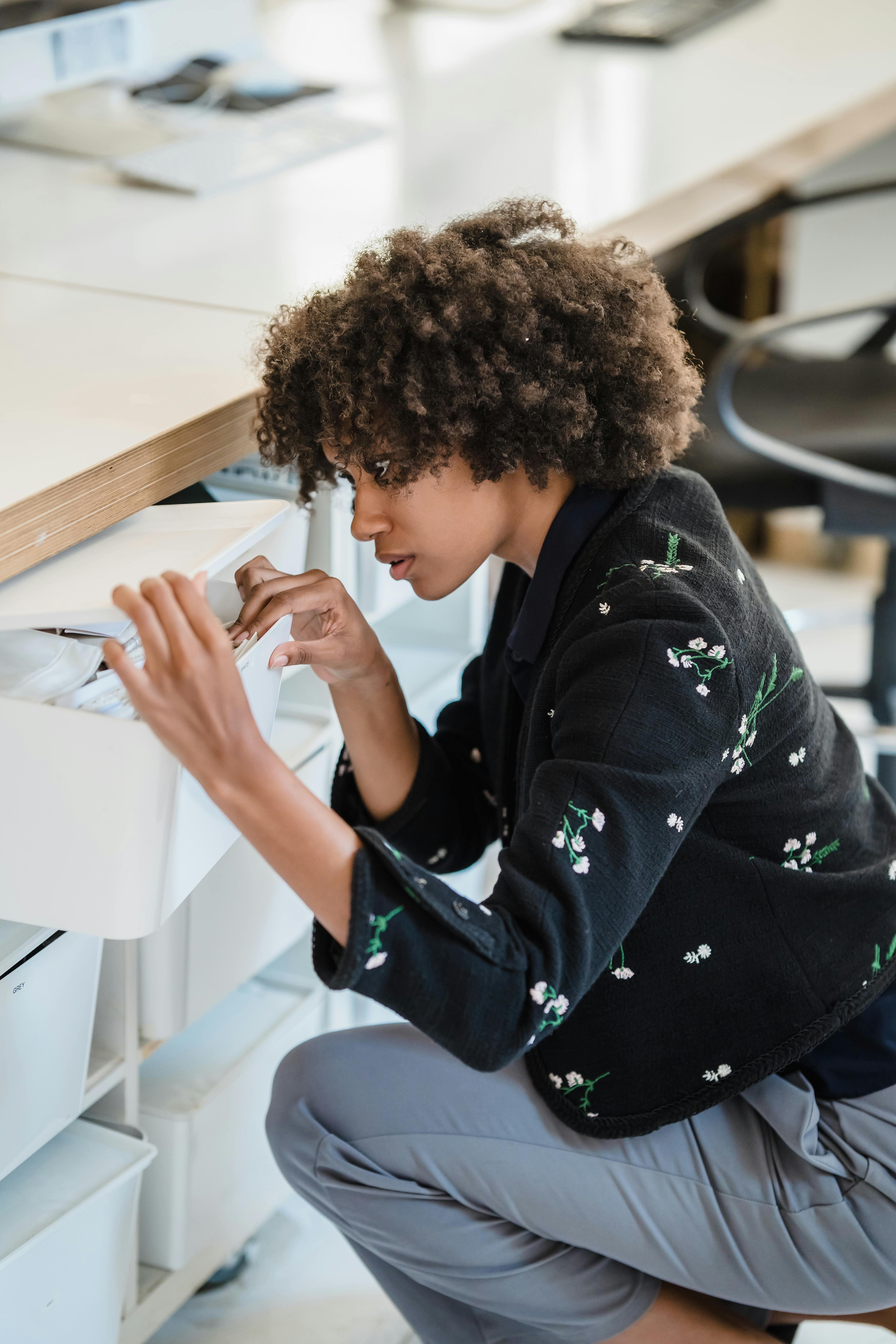 Una mujer buscando en los cajones de su escritorio | Fuente: Pexels