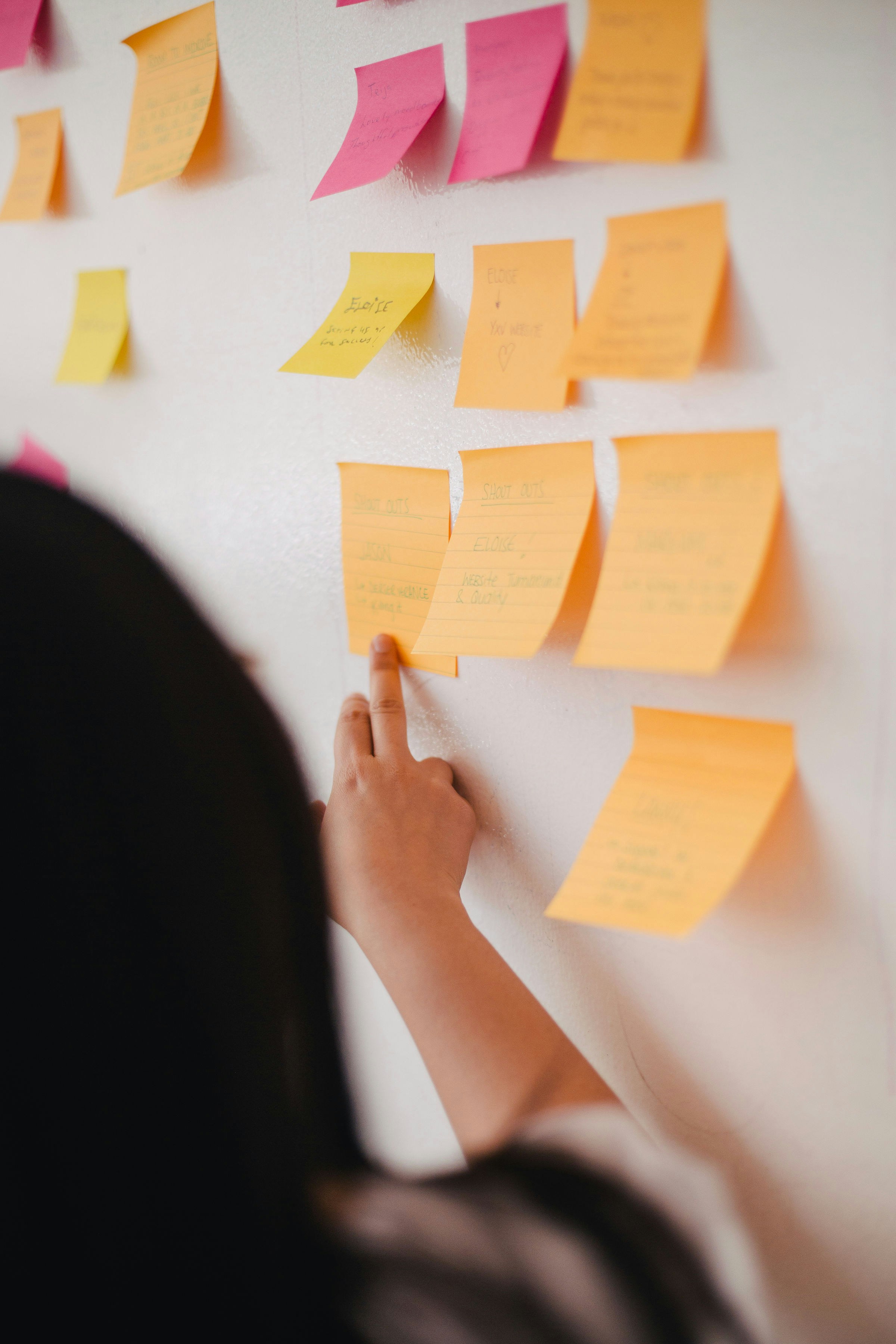A woman looking at sticky notes | Source: Unsplash