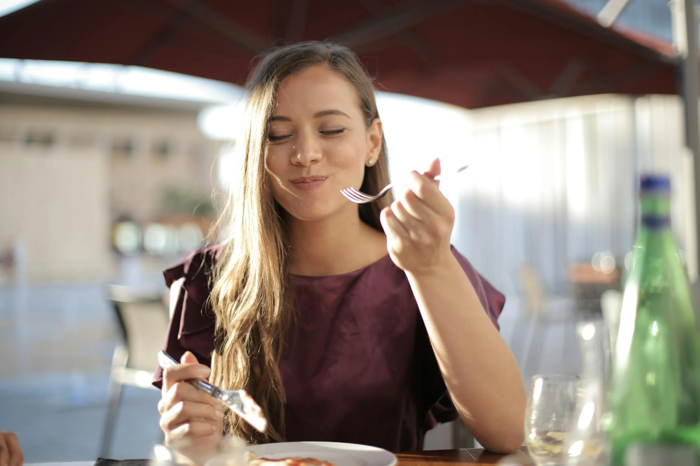 A smiling woman eating in a cafe | Source: Pexels