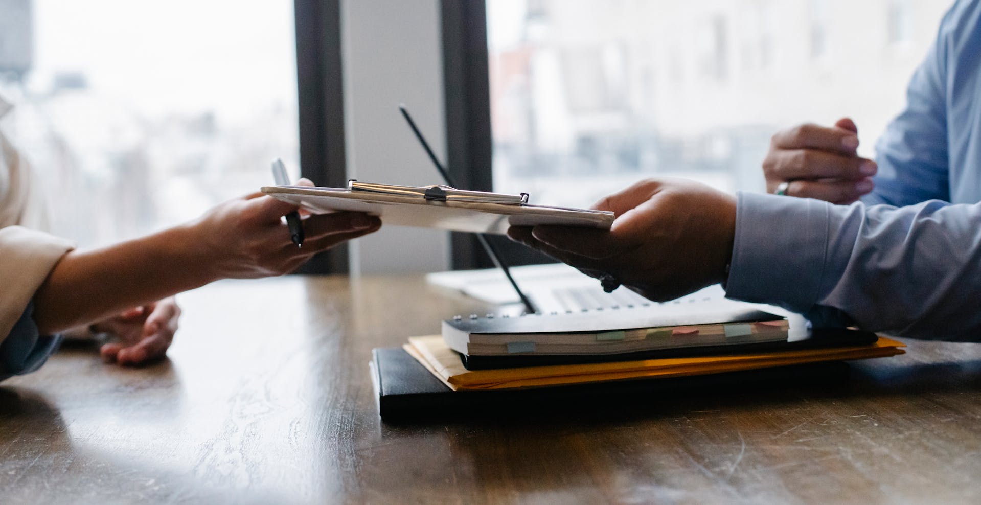 A woman passing her resume to an employer | Source: Pexels
