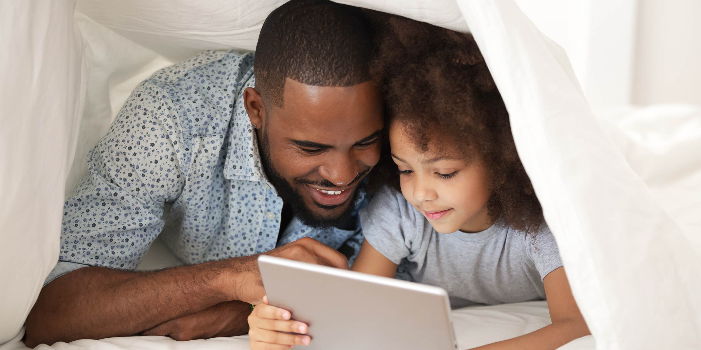 A father and daughter duo using a Tablet | Source: Shutterstock