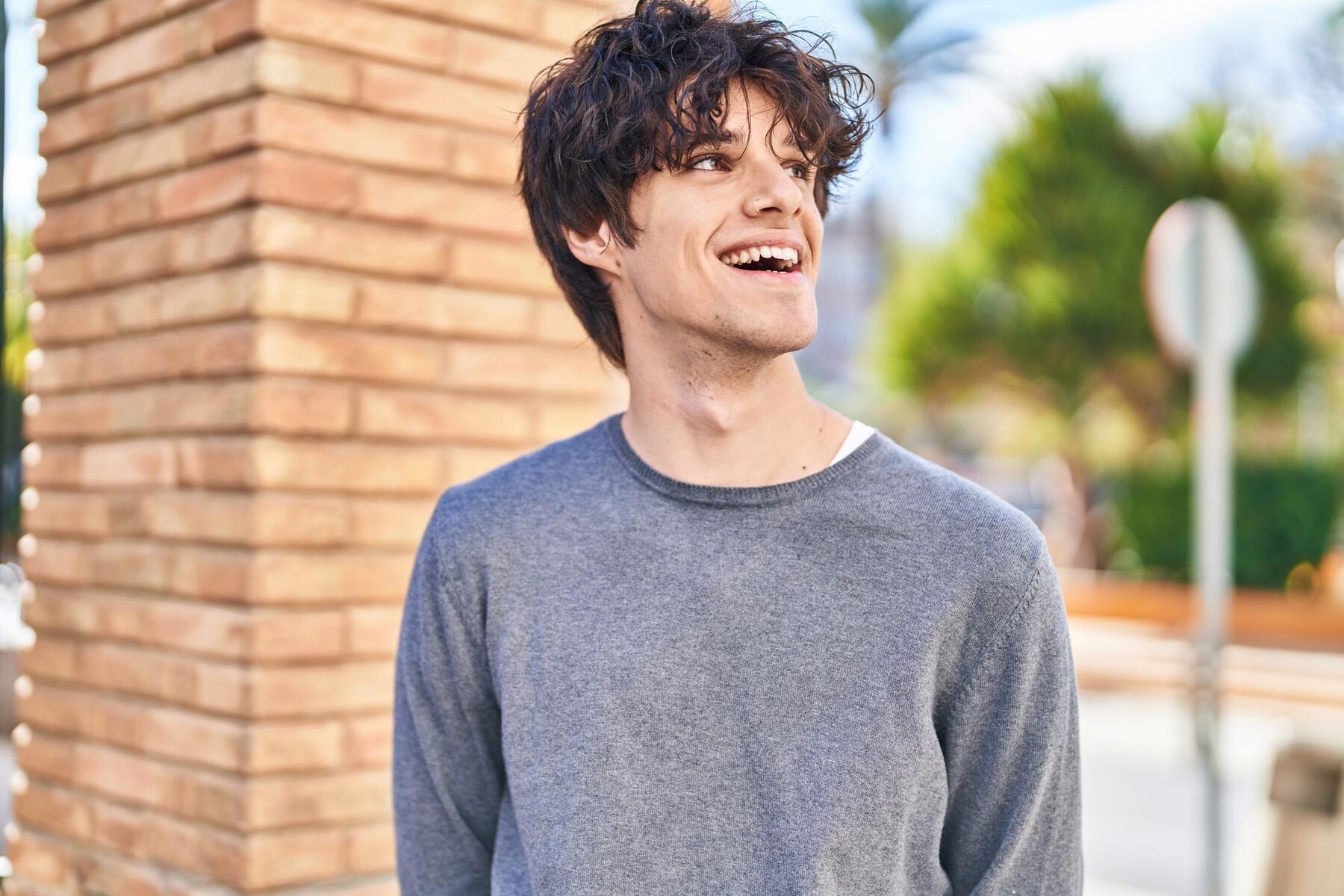 A smiling young man on a street | Source: Freepik