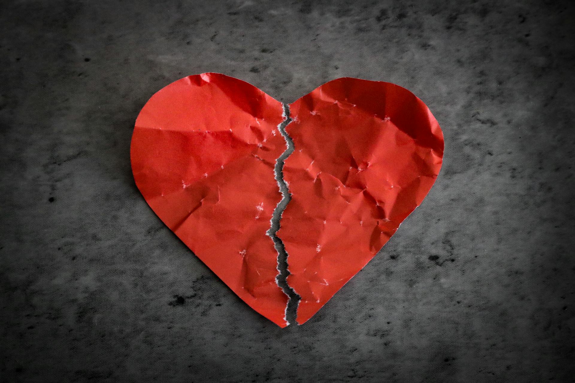 A red paper heart ripped in half | Source: Pexels