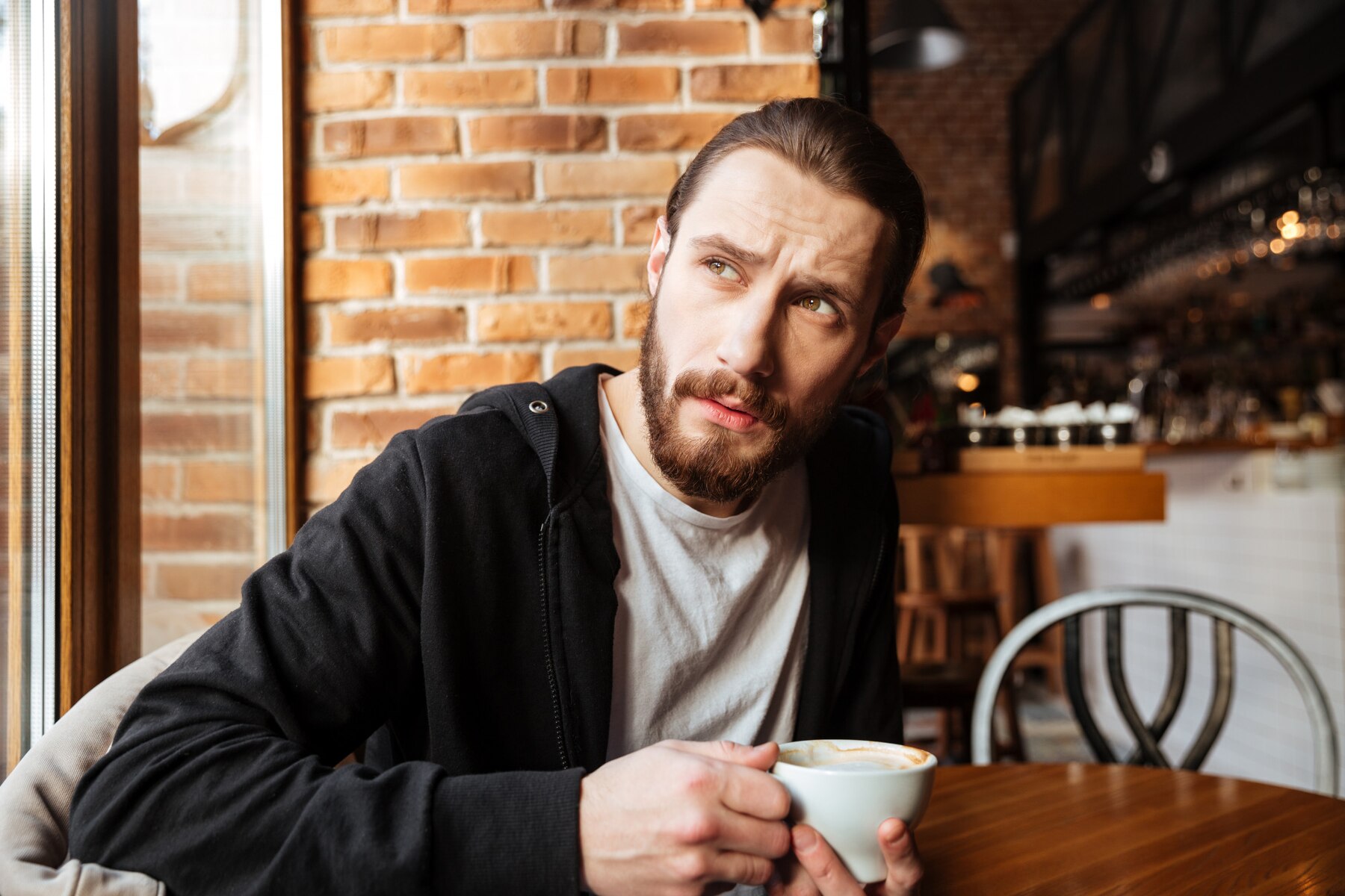 A thoughtful man in a cafe | Source: Freepik