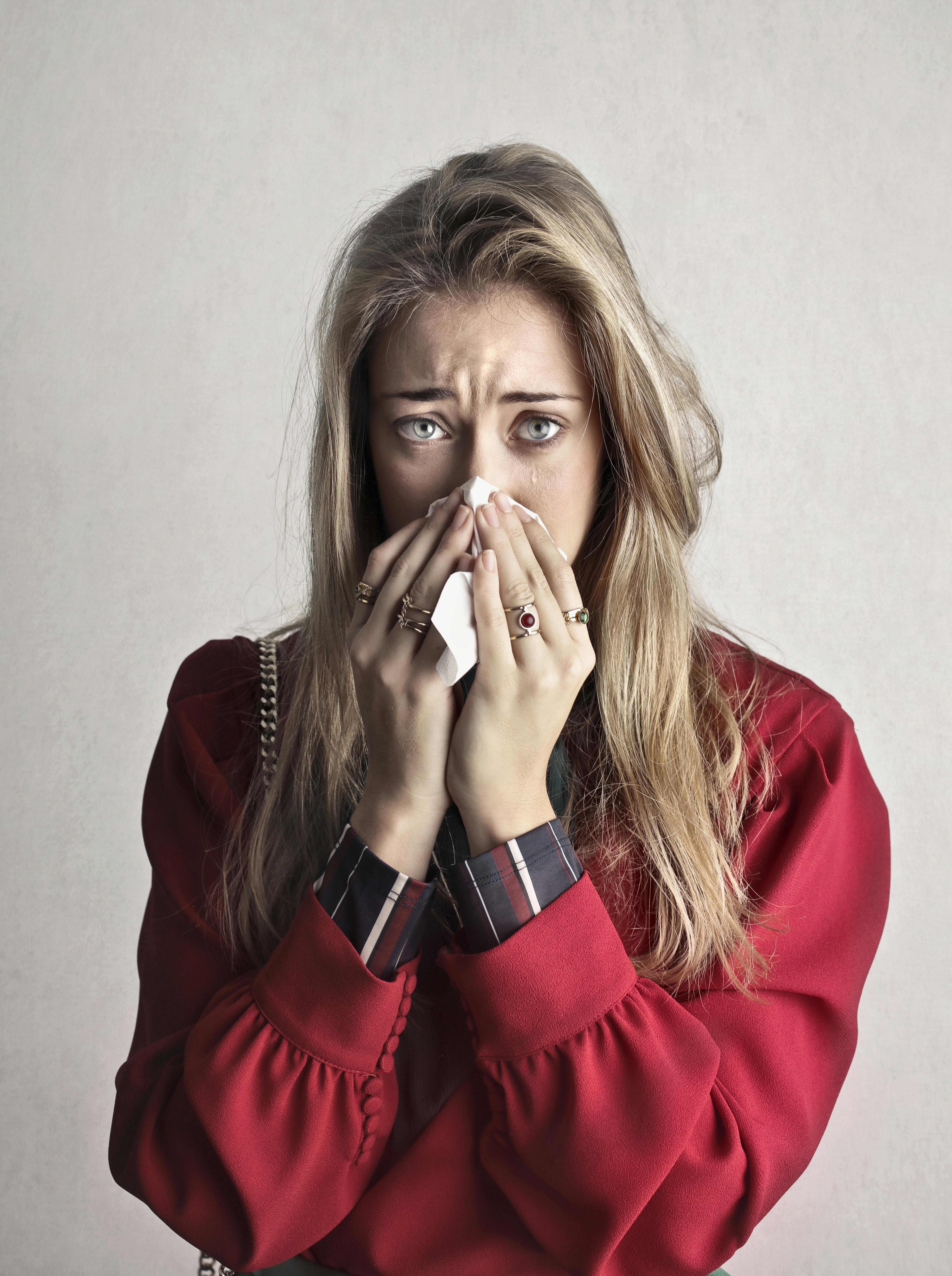 A crying woman rubbing her nose | Source: Pexels