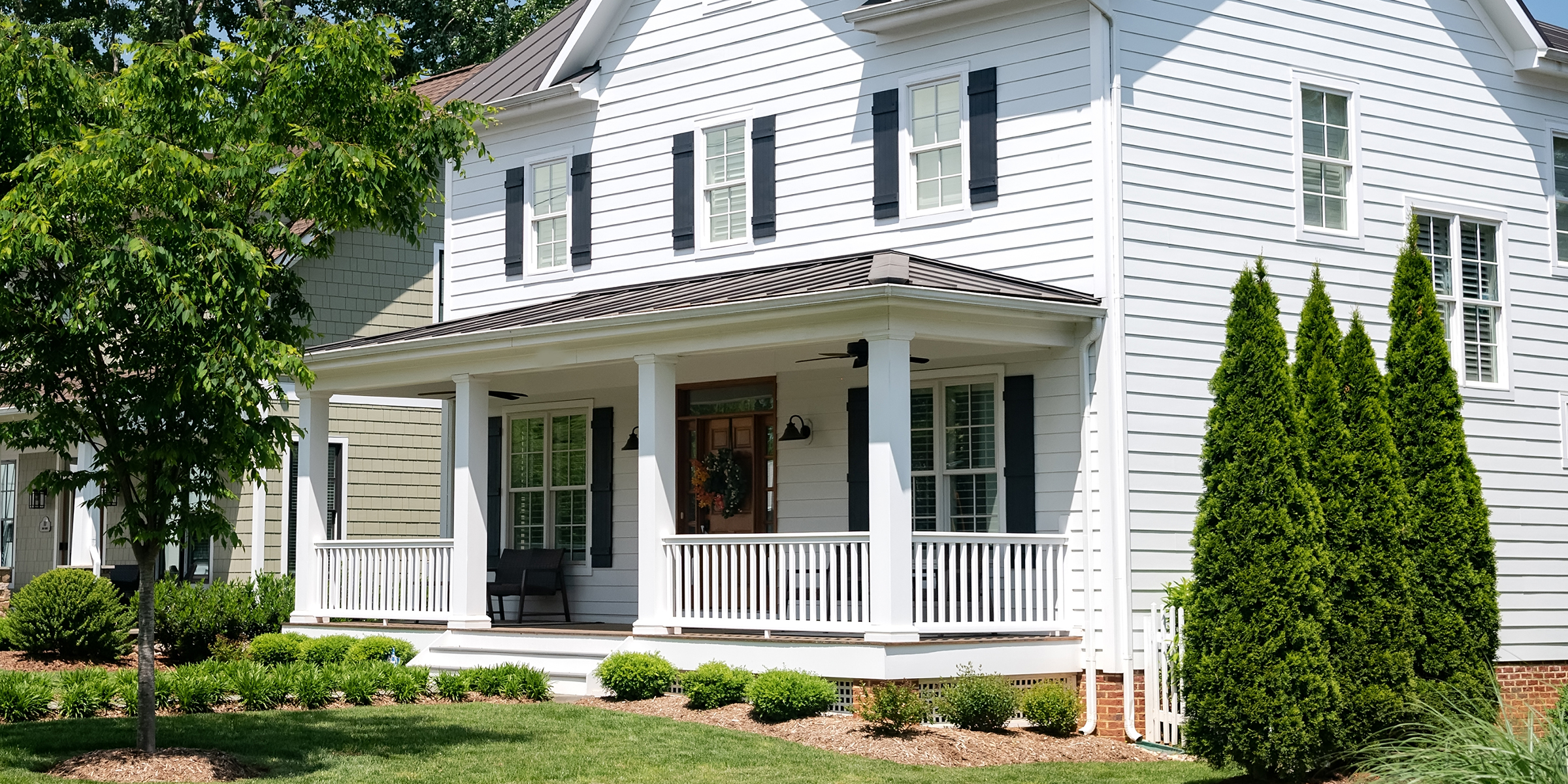 A classic white house with a wraparound porch | Source: Shutterstock