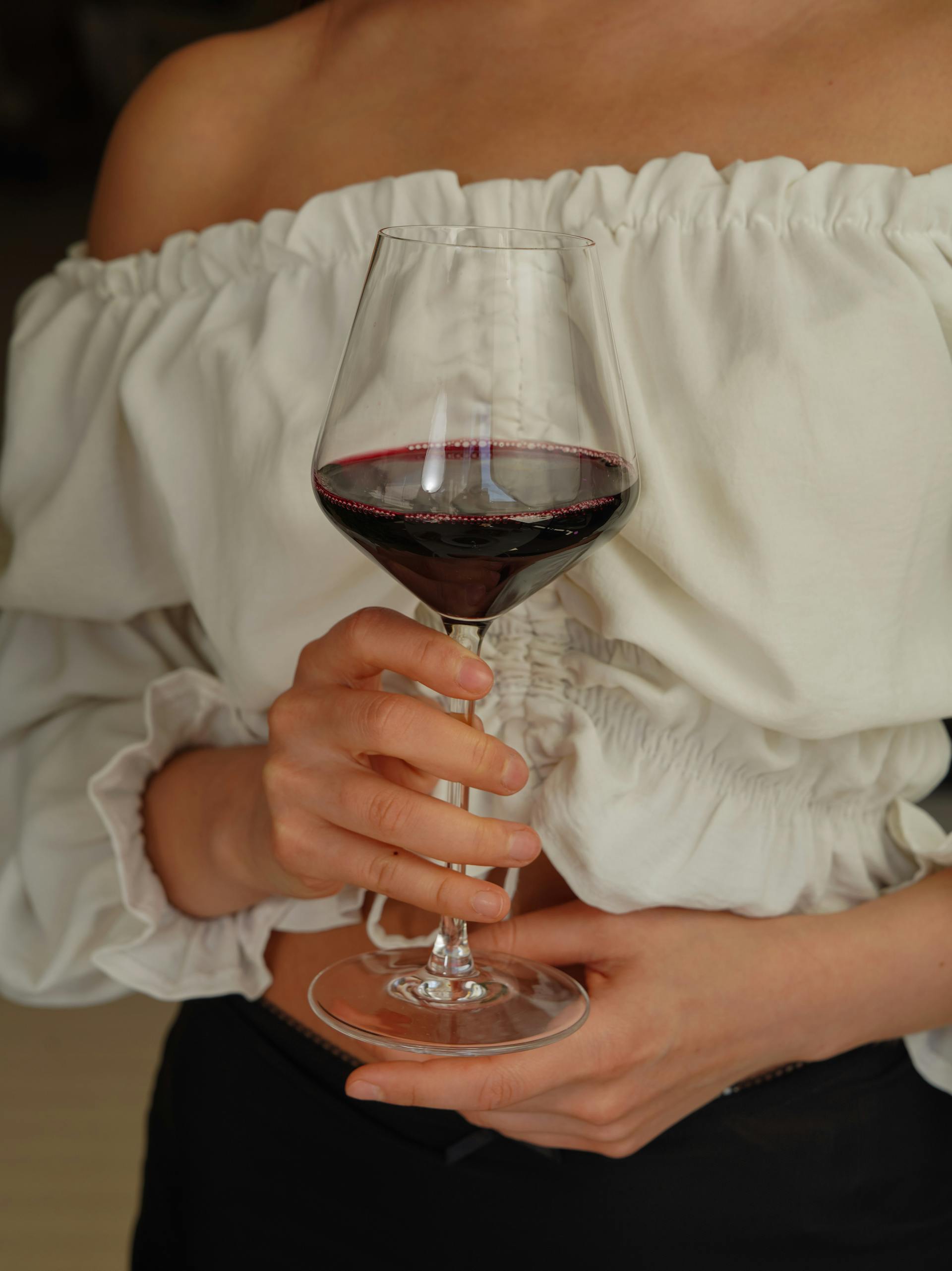 A closeup shot of a woman holding a glass of wine | Source: Pexels