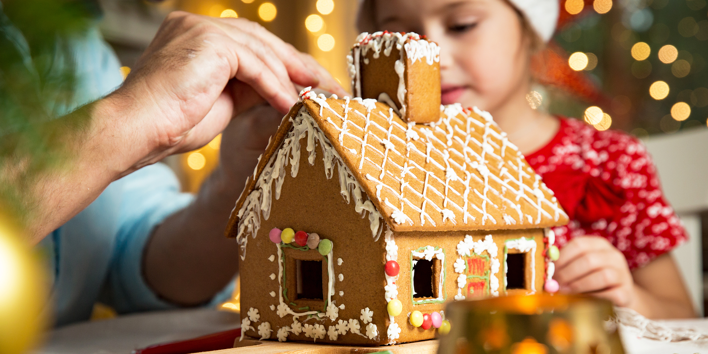 A little girl with a gingerbread house | Source: Shutterstock